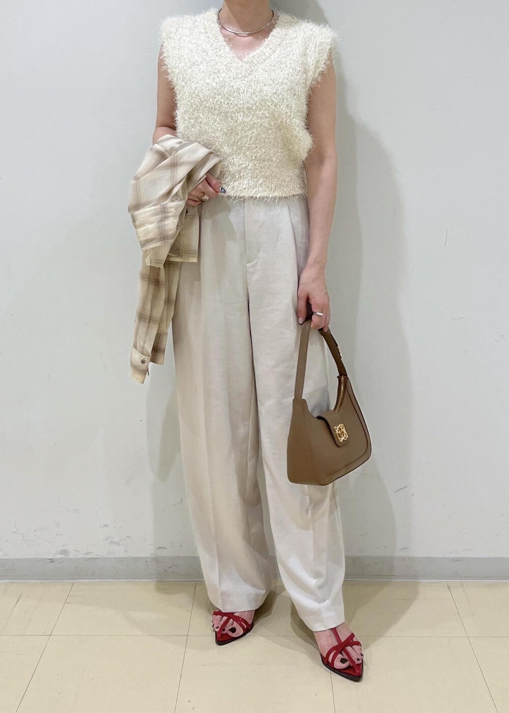 レッド系のサンダル、ベージュ系のシャツ/ブラウス、ホワイト系のスラックスを着用したレディースの夏コーディネートの5枚目の写真