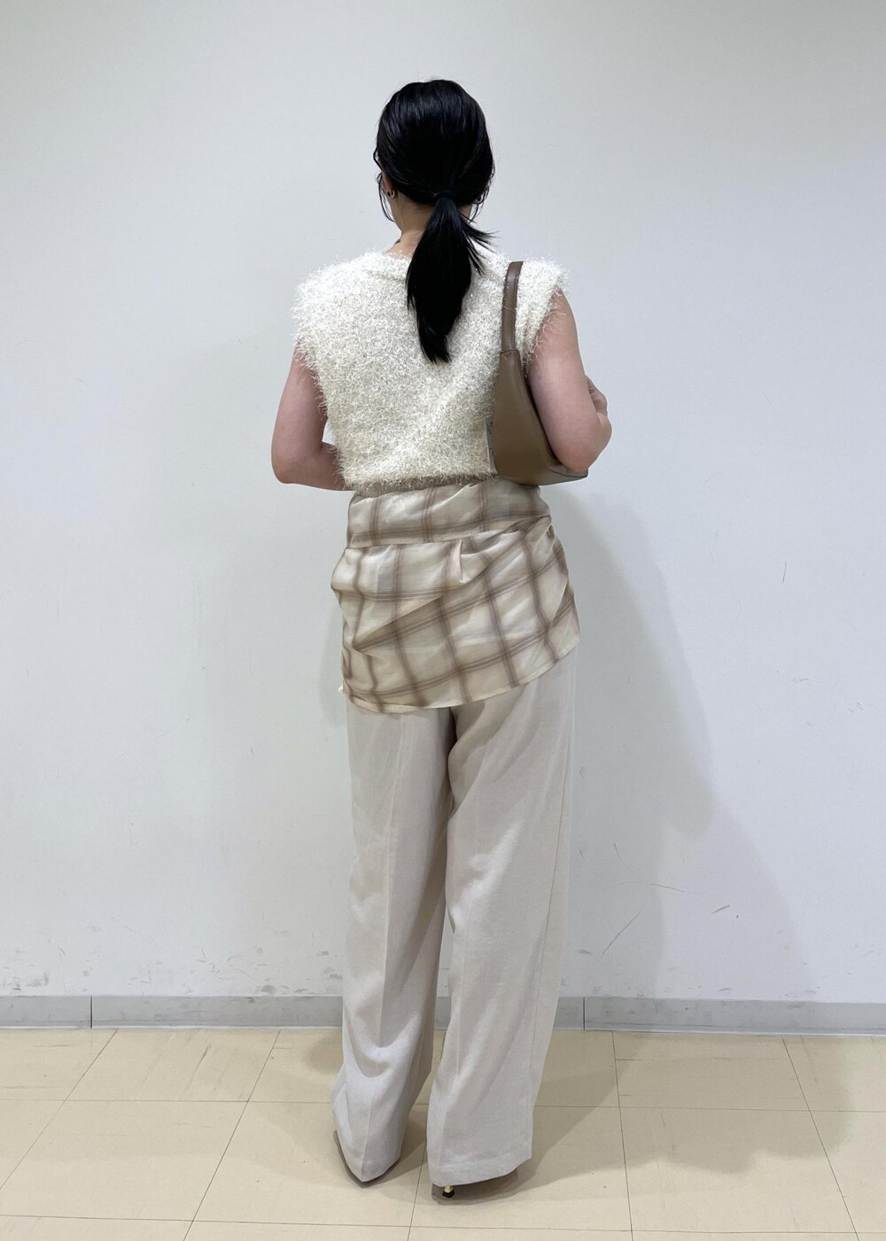 レッド系のサンダル、ベージュ系のシャツ/ブラウス、ホワイト系のスラックスを着用したレディースの夏コーディネートの4枚目の写真