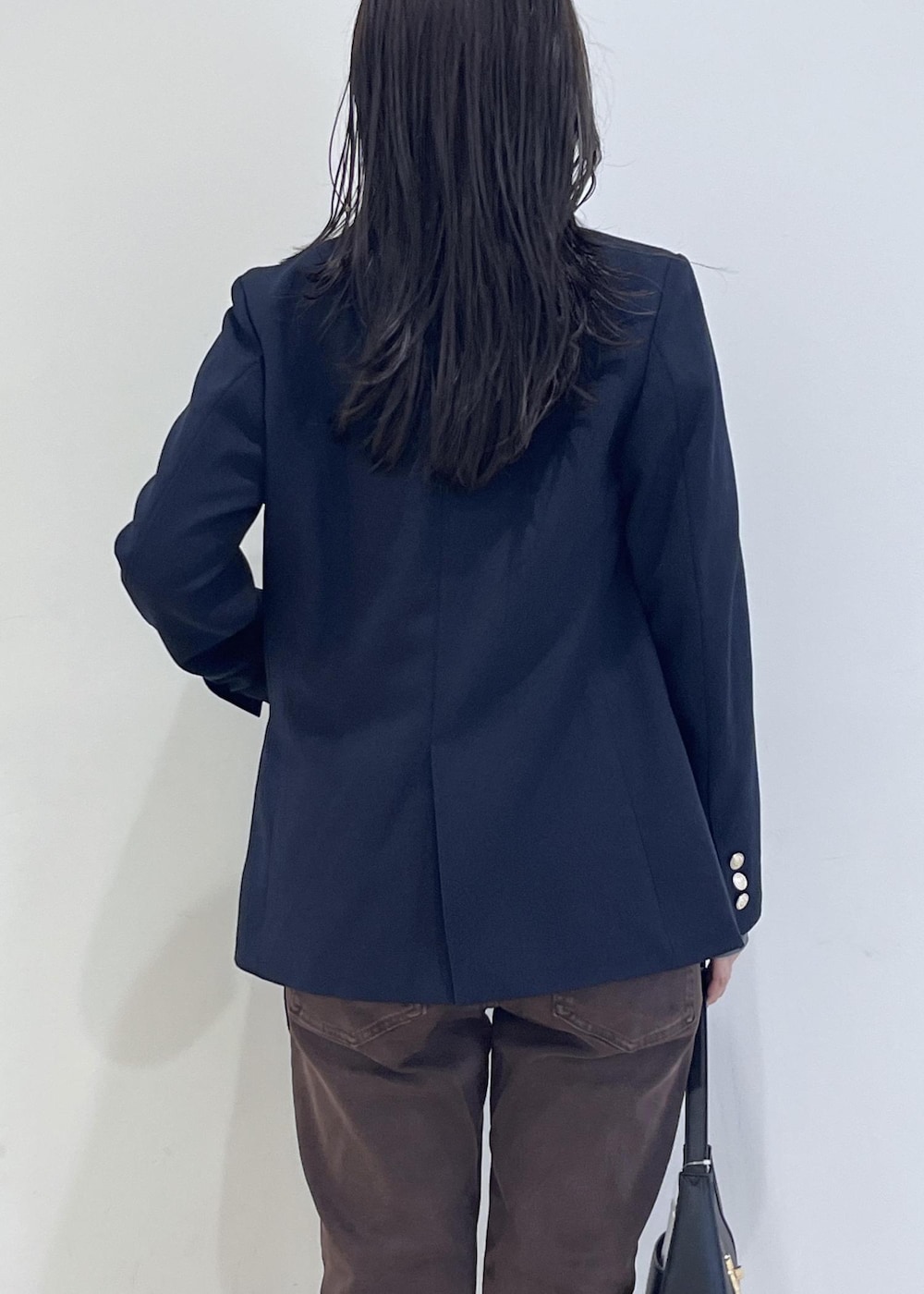 ブラック系のショルダーバッグ、ブルー系のテーラードジャケット、ブルー系のTシャツ/カットソーを着用したレディースの秋コーディネートの8枚目の写真