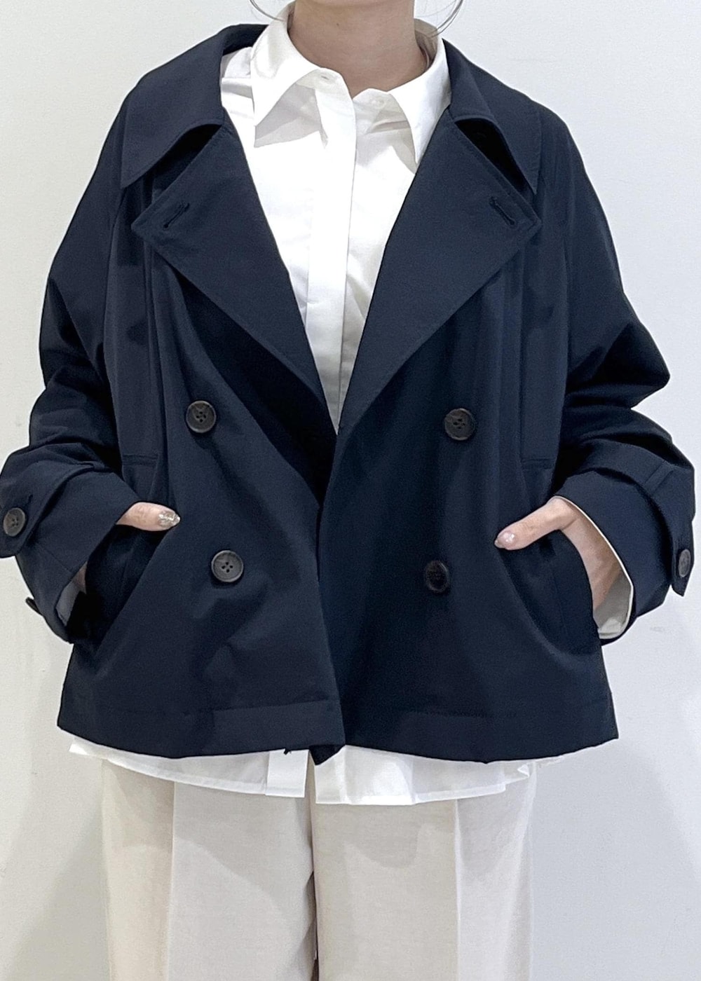 ブラック系のパンプス、ベージュ系のショルダーバッグ、ブルー系のトレンチコートを着用したレディースの春コーディネートの8枚目の写真