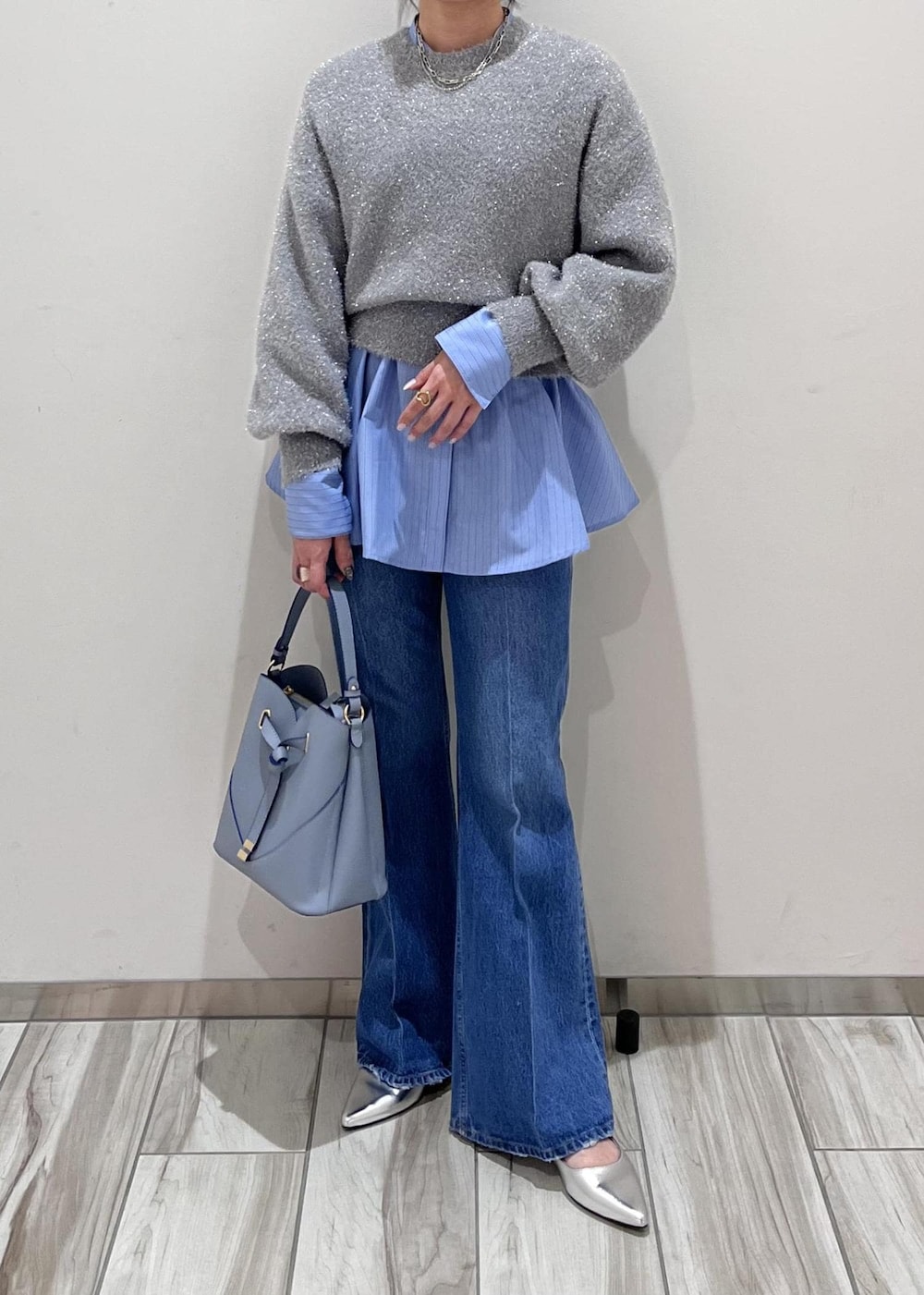 シルバー系のパンプス、ブルー系のデニムパンツ、ブルー系のシャツ/ブラウスを着用したレディースの冬コーディネートの3枚目の写真