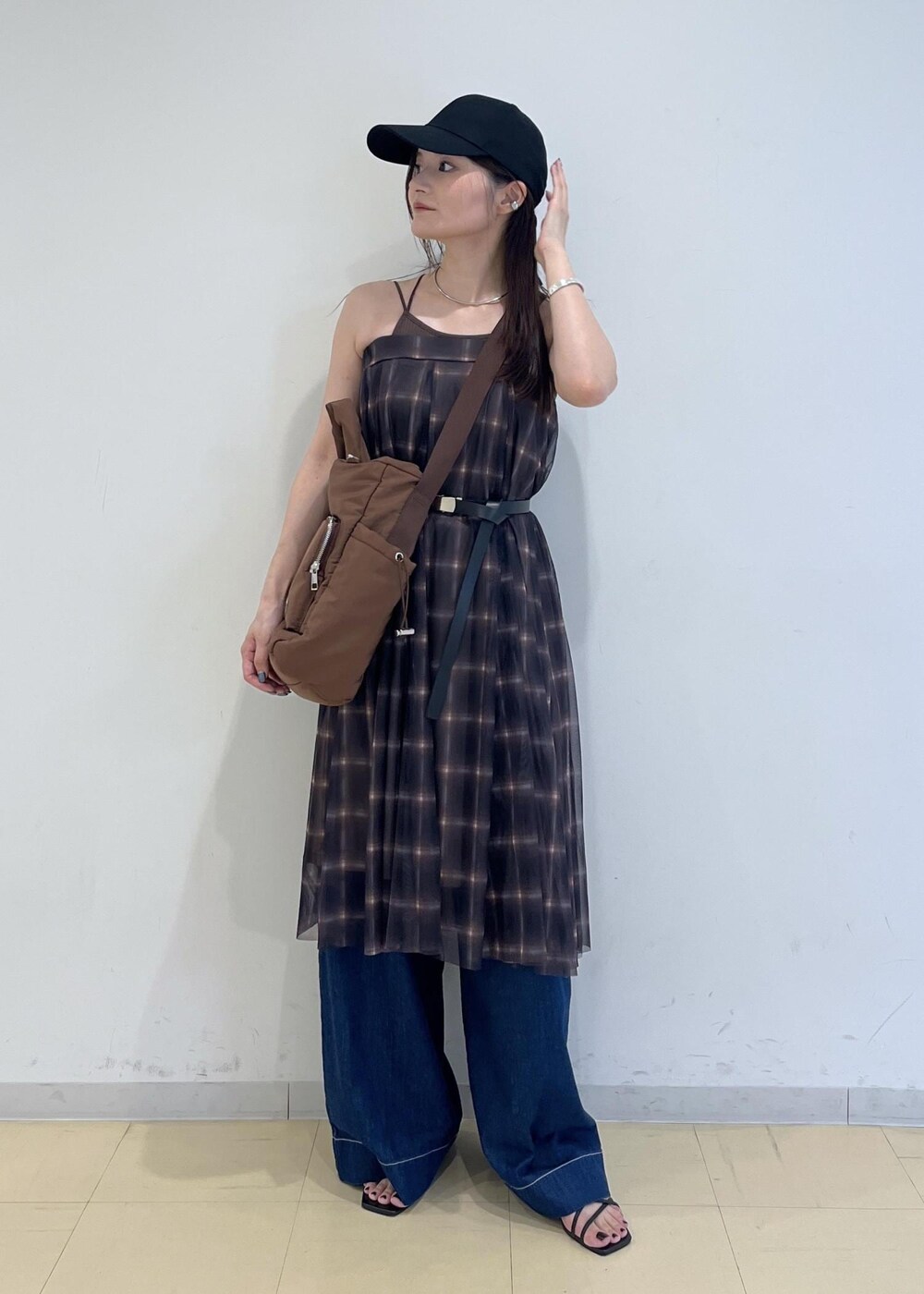 ブルー系のデニムパンツ、ブラウン系のスカート、ブラウン系のキャミソールを着用したレディースの夏コーディネートの10枚目の写真