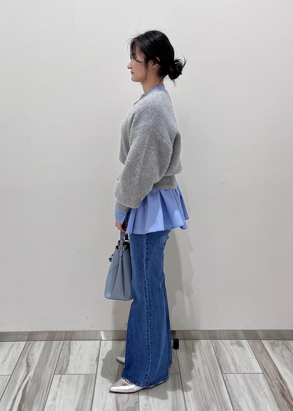 シルバー系のパンプス、ブルー系のデニムパンツ、ブルー系のシャツ/ブラウスを着用したレディースの冬コーディネートの2枚目の写真