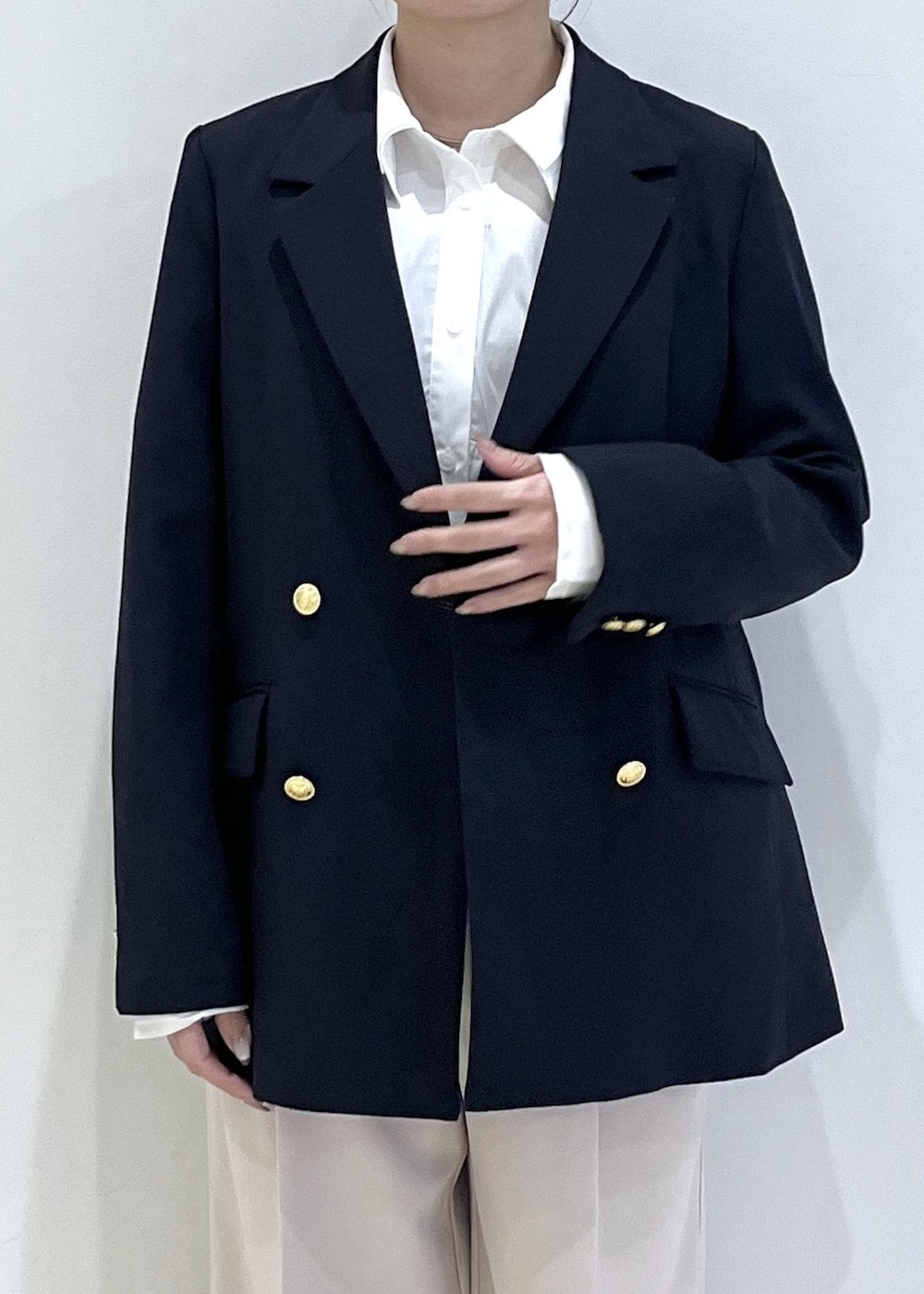 ホワイト系のシャツ/ブラウス、ホワイト系のニット/セーター、ブルー系のテーラードジャケットを着用したレディースの冬コーディネートの7枚目の写真