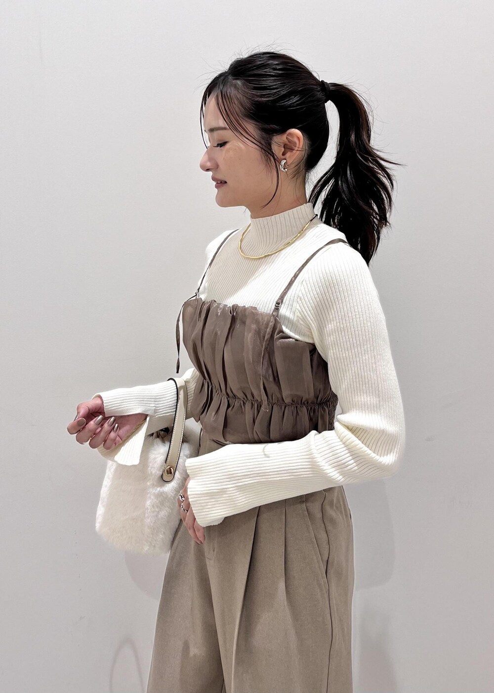 ホワイト系のショルダーバッグ、ホワイト系のブーツ、ホワイト系のブルゾンを着用したレディースの秋コーディネートの10枚目の写真