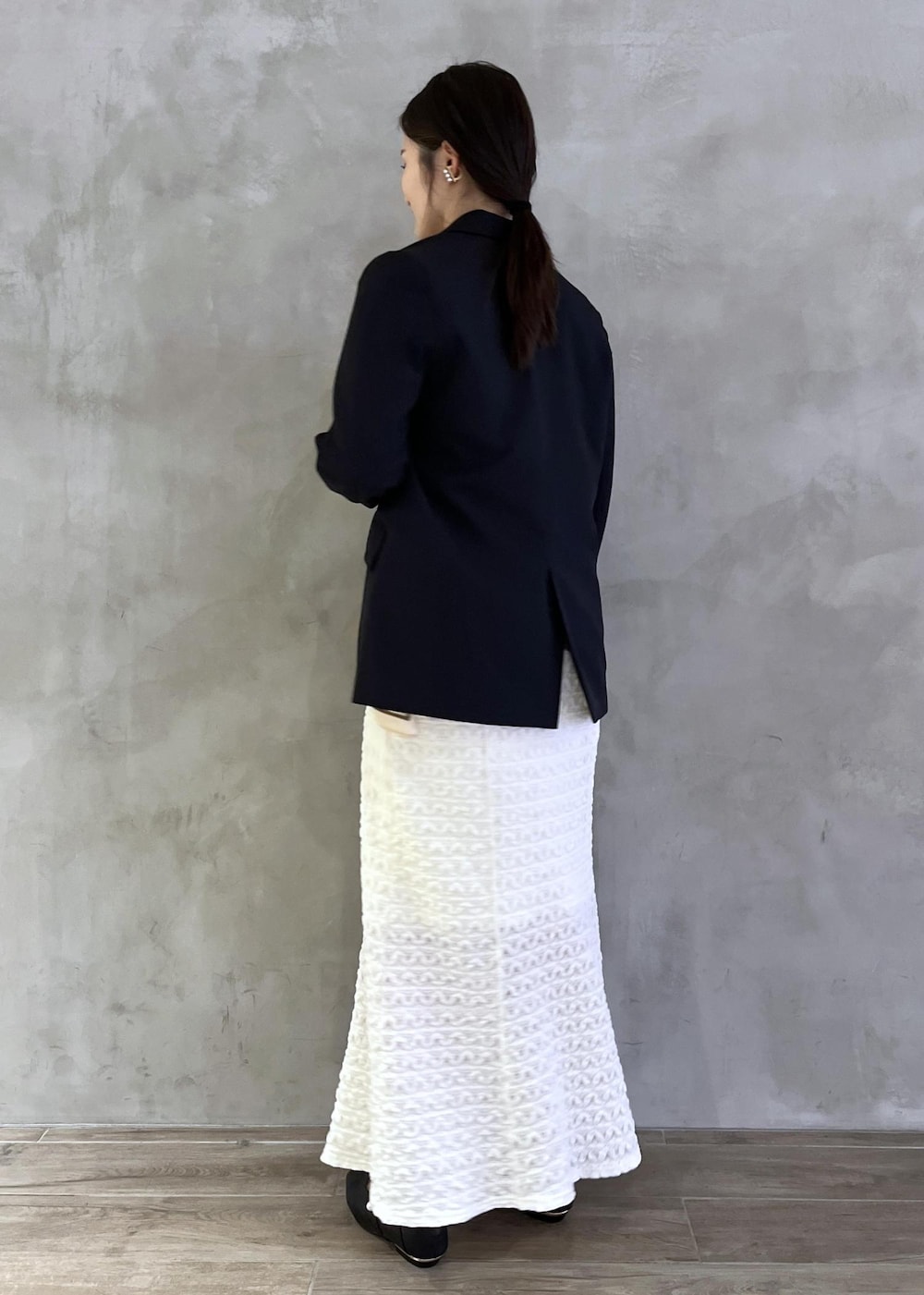 ブラック系のパンプス、ホワイト系のワンピース、ブルー系のテーラードジャケットを着用したレディースの春コーディネートの3枚目の写真