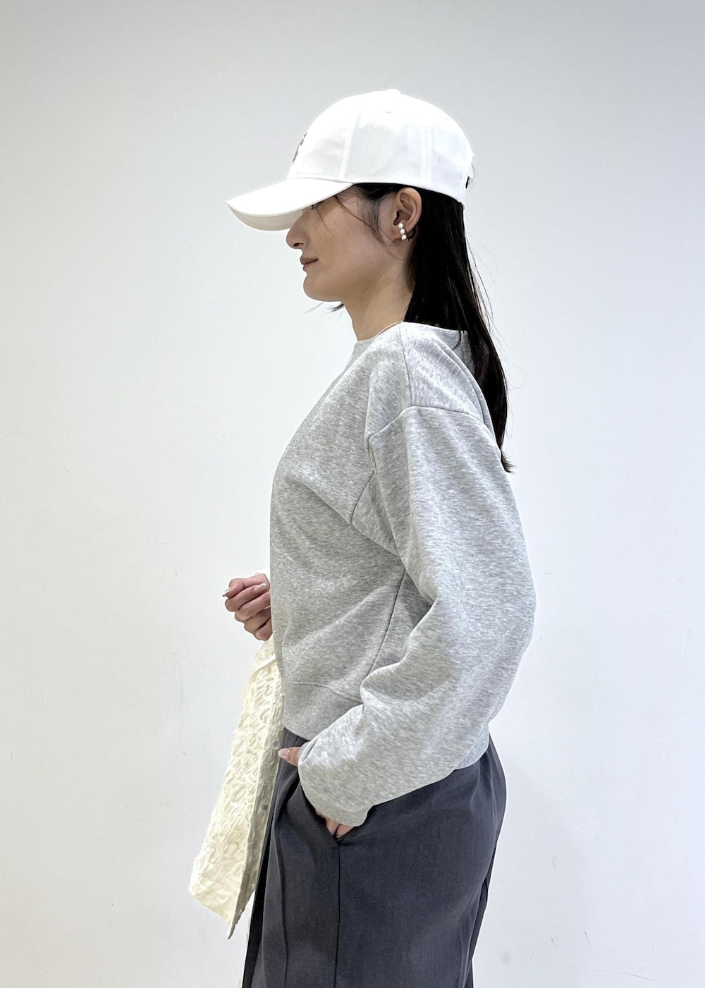 ホワイト系のパンプス、ブラック系のショルダーバッグ、ホワイト系のカーディガン/ボレロを着用したレディースの春コーディネートの6枚目の写真