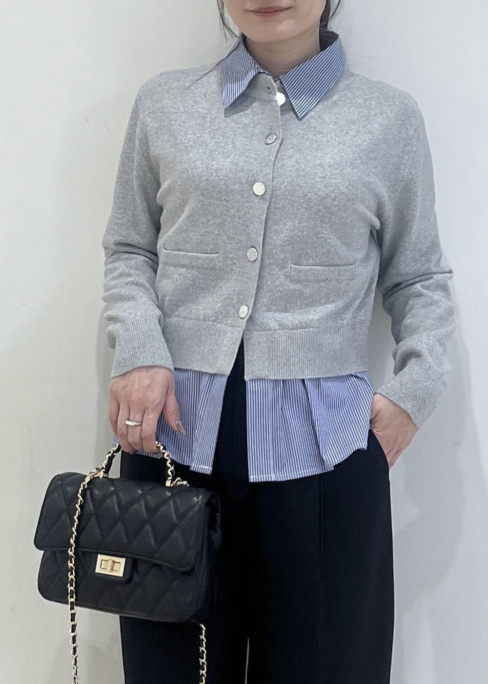 ホワイト系のパンプス、グレー系のカーディガン/ボレロ、ブラック系のスラックスを着用したレディースの冬コーディネートの4枚目の写真