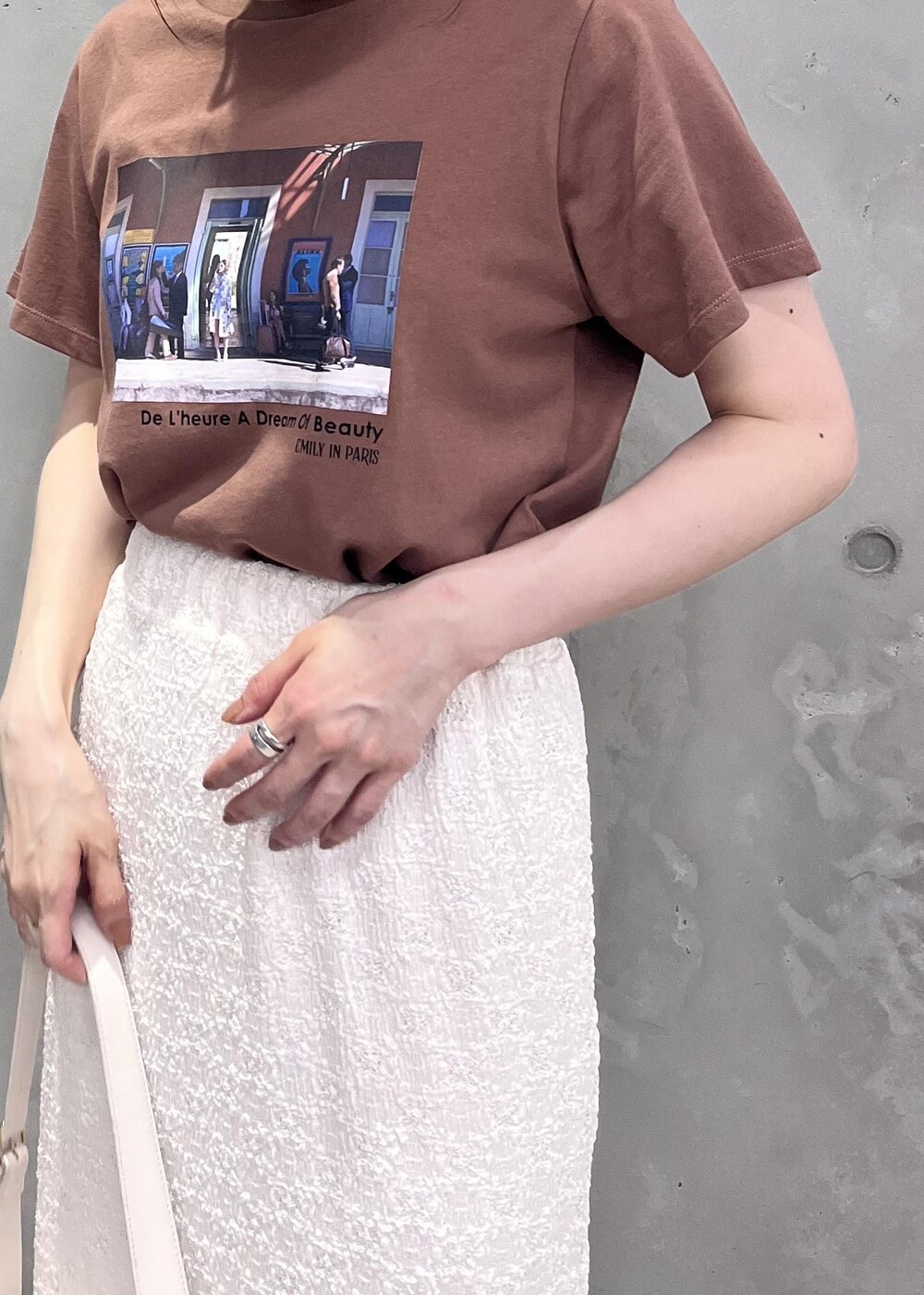 ホワイト系のショルダーバッグ、ホワイト系のサンダル、ブラウン系のTシャツ/カットソーを着用したレディースの夏コーディネートの2枚目の写真