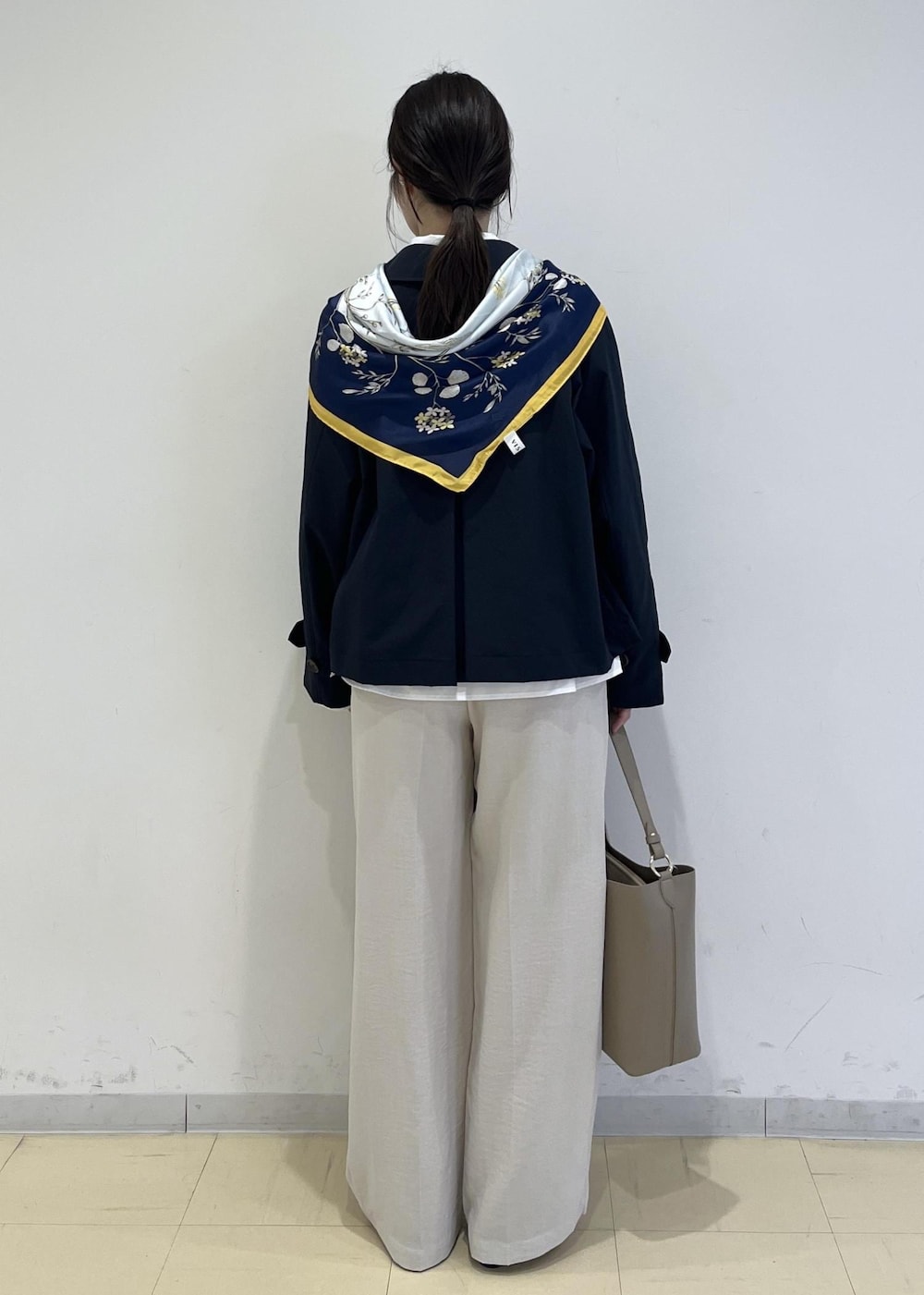 ブラック系のパンプス、ベージュ系のショルダーバッグ、ブルー系のトレンチコートを着用したレディースの春コーディネートの3枚目の写真