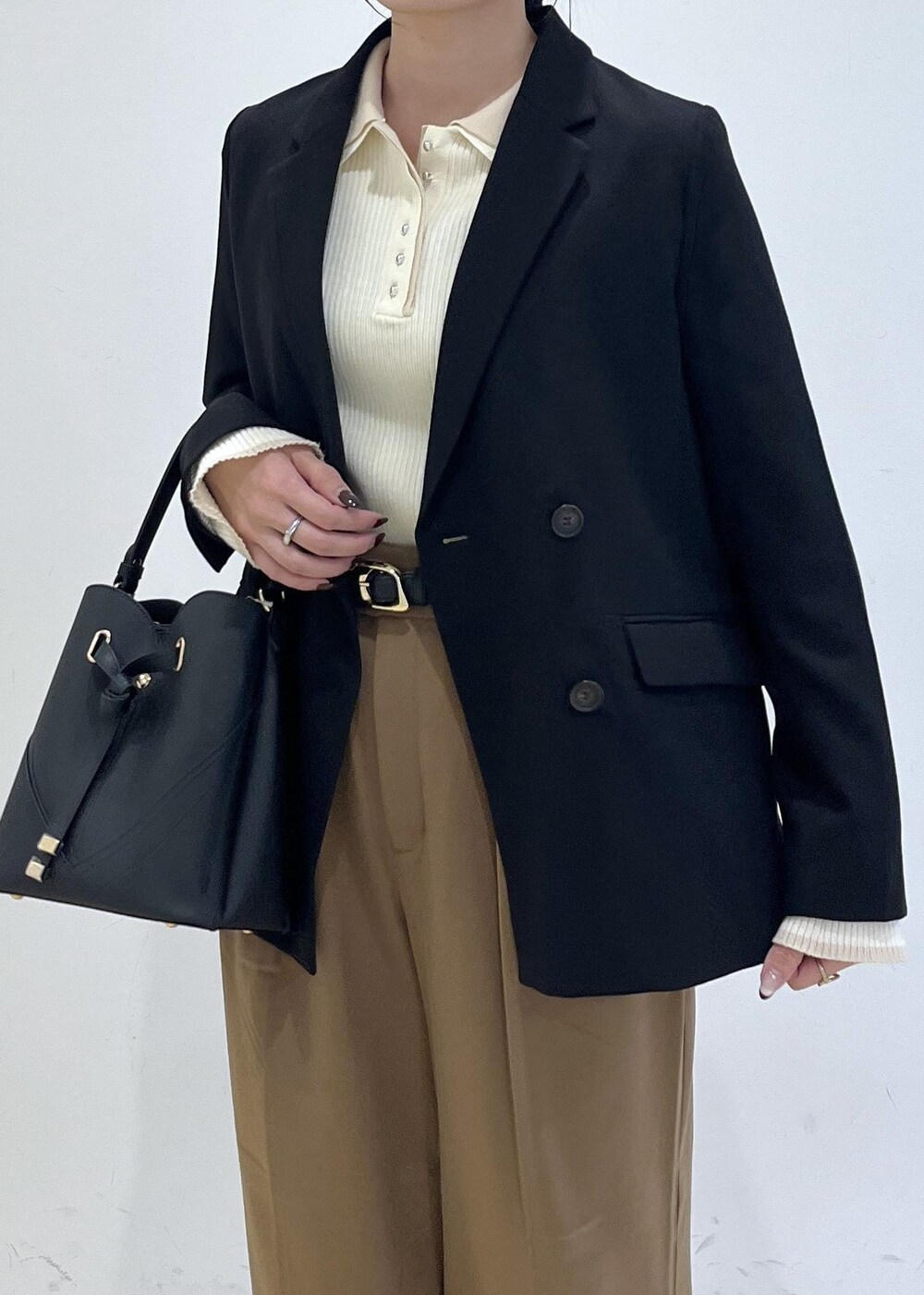 ブラック系のショルダーバッグ、ブラック系のテーラードジャケット、イエロー系のその他パンツを着用したレディースの秋コーディネートの6枚目の写真