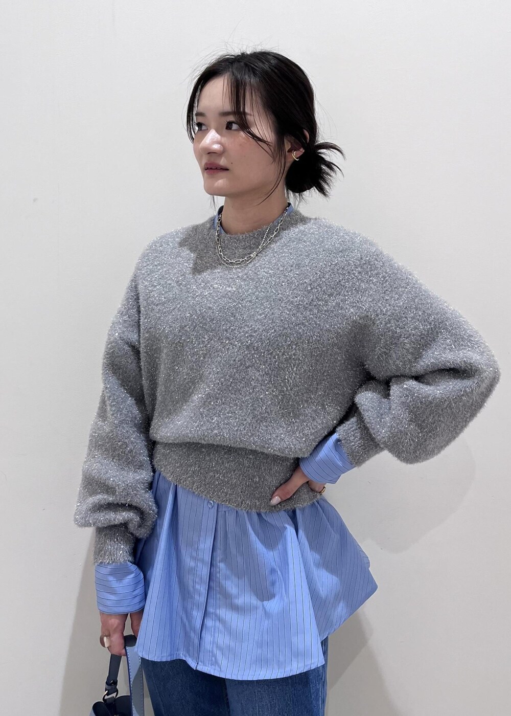 シルバー系のパンプス、ブルー系のデニムパンツ、ブルー系のシャツ/ブラウスを着用したレディースの冬コーディネートの9枚目の写真