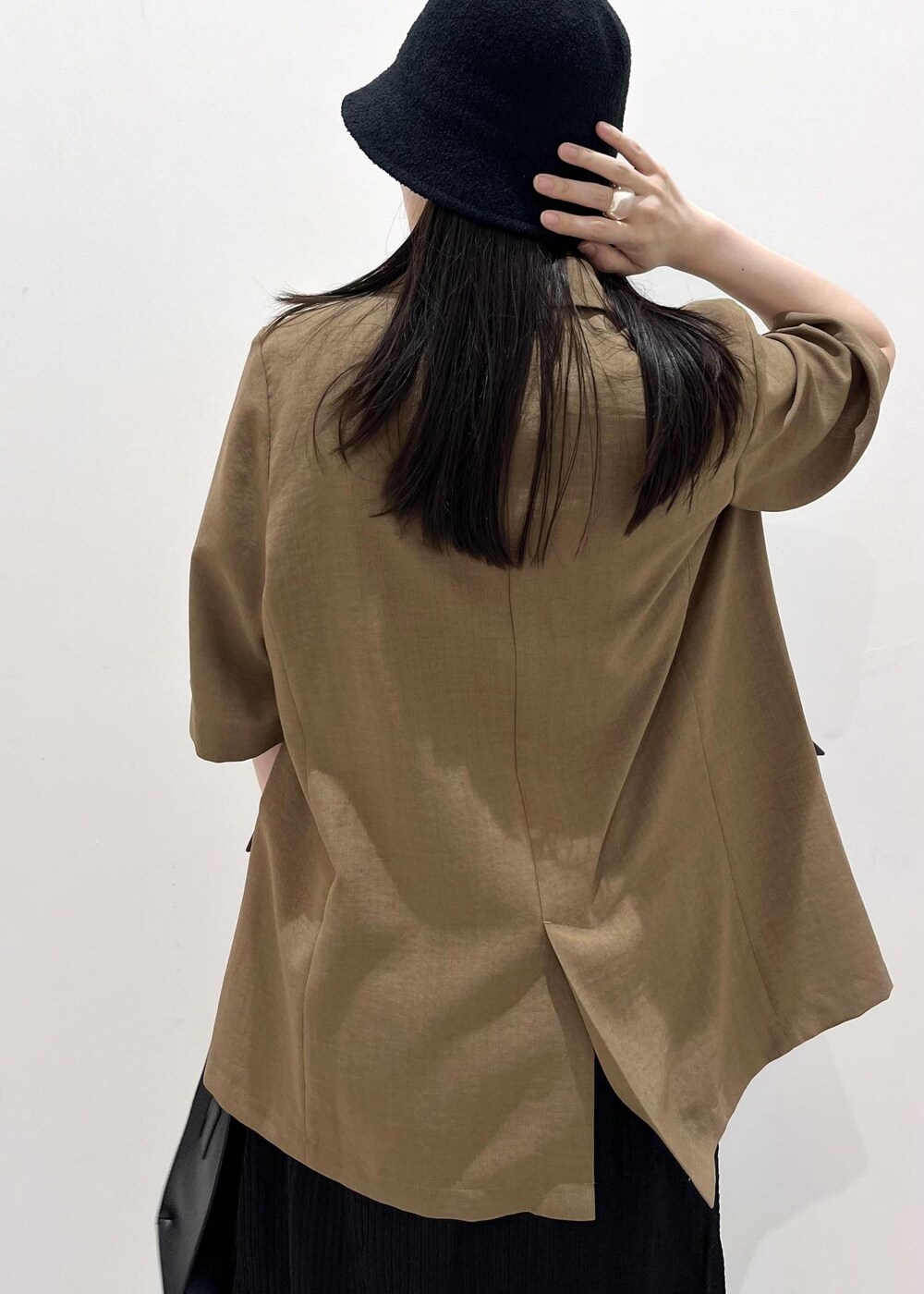 ブラック系のサンダル、ブラック系のハンドバッグ、ブラウン系のテーラードジャケットを着用したレディースの夏コーディネートの5枚目の写真