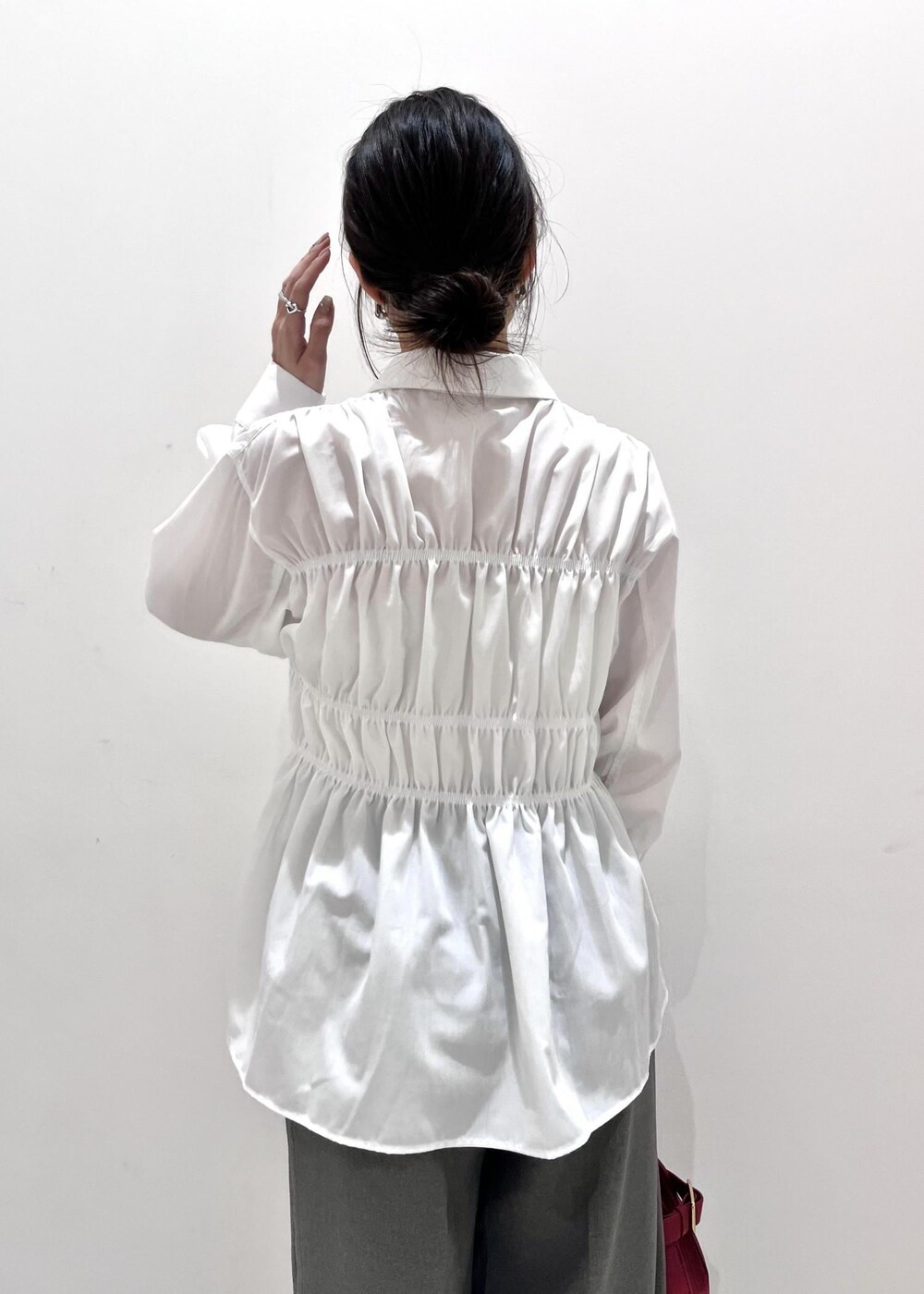 レッド系のトートバッグ、ブラック系のブーツ、ブラック系のカーディガン/ボレロを着用したレディースの秋コーディネートの9枚目の写真