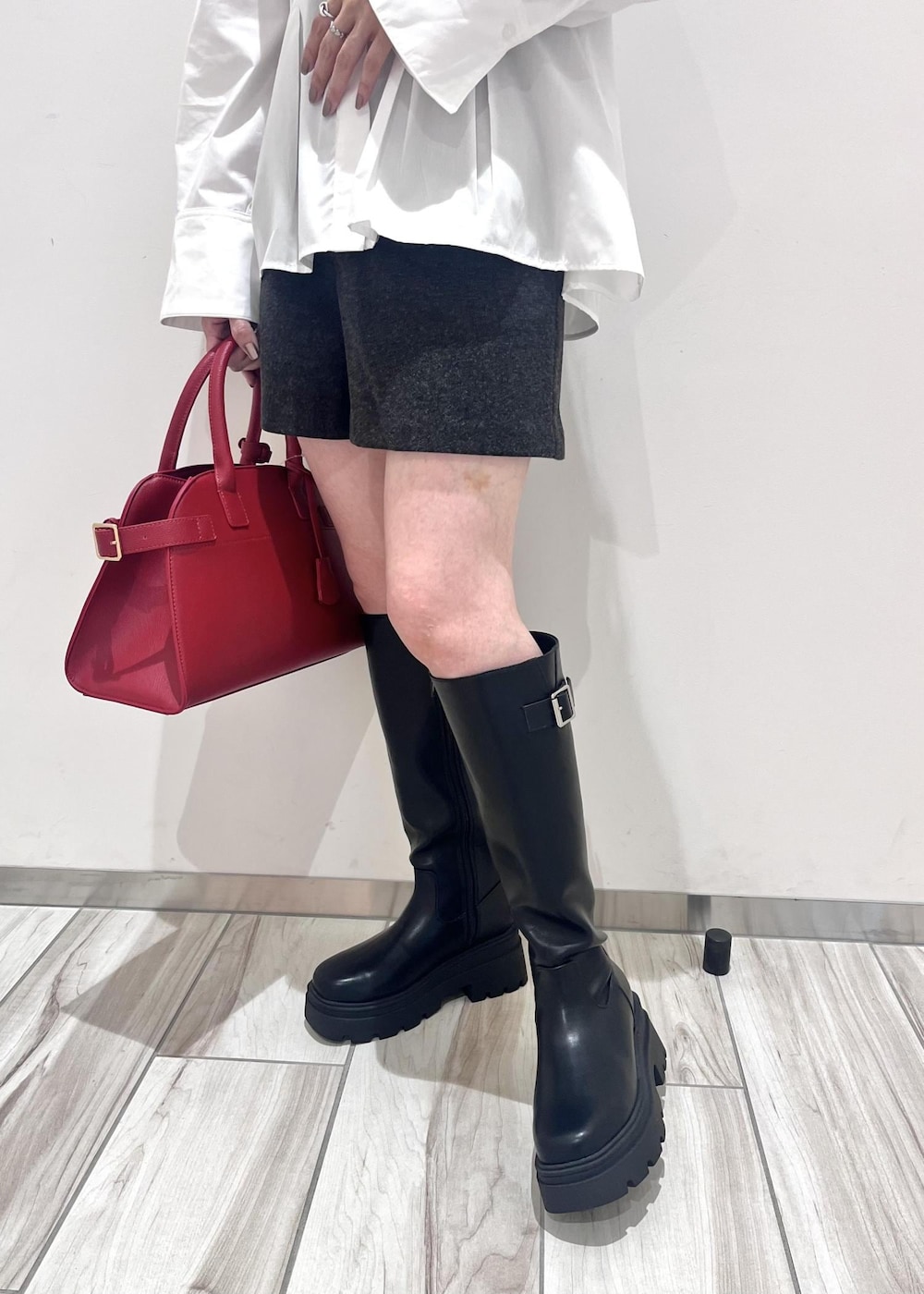 レッド系のトートバッグ、グレー系のその他パンツ、ブラック系のブーツを着用したレディースの秋コーディネートの10枚目の写真