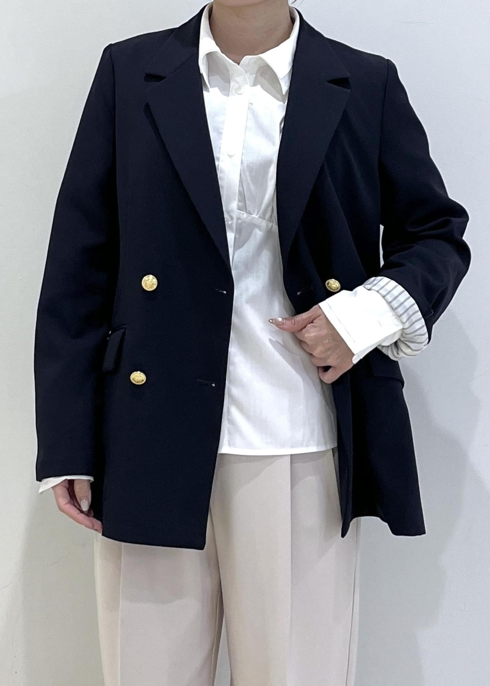 ホワイト系のシャツ/ブラウス、ホワイト系のニット/セーター、ブルー系のテーラードジャケットを着用したレディースの冬コーディネートの6枚目の写真