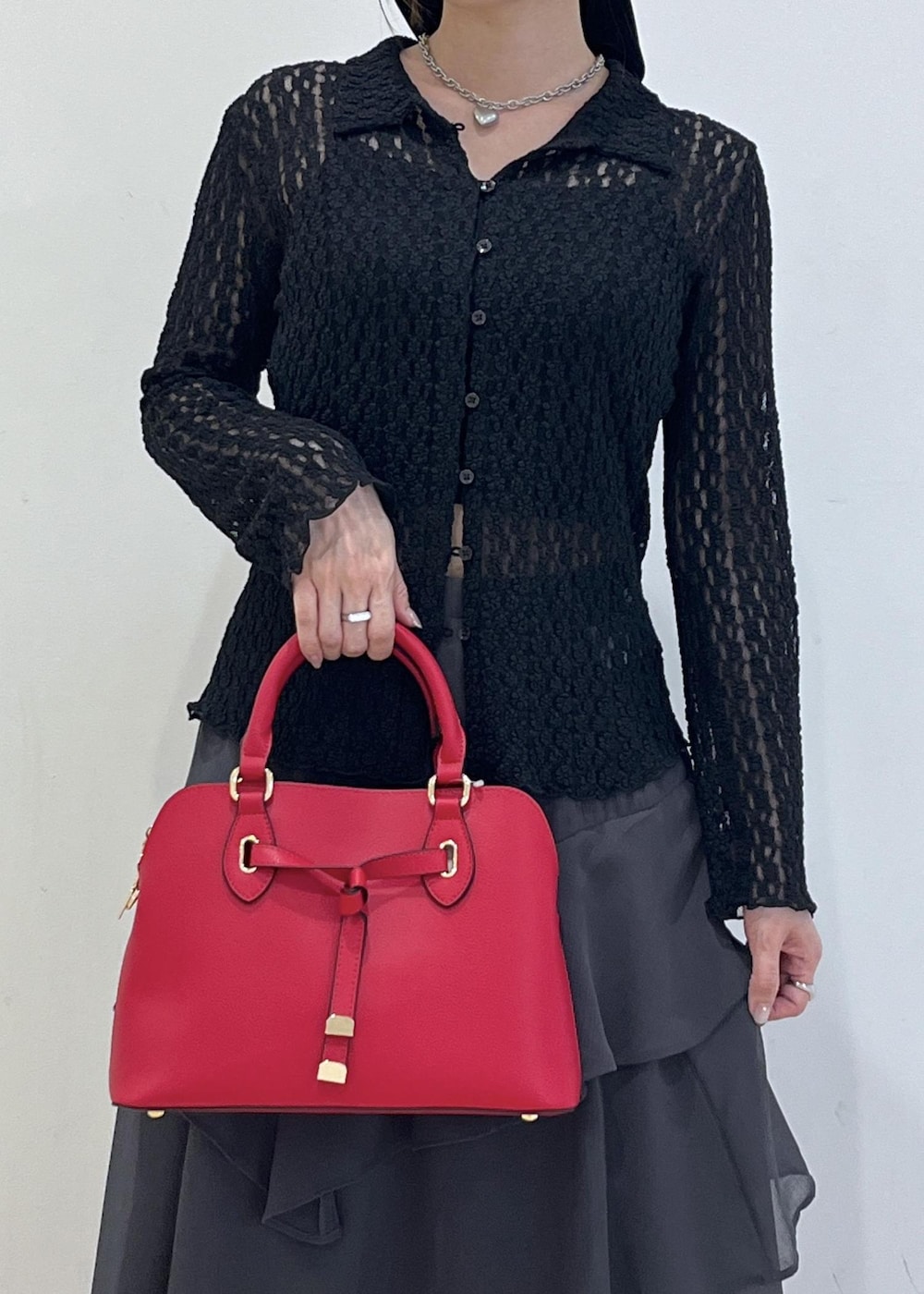 ブラック系のカーディガン/ボレロ、レッド系のボストンバッグ、グレー系のスカートを着用したレディースの秋コーディネートの3枚目の写真