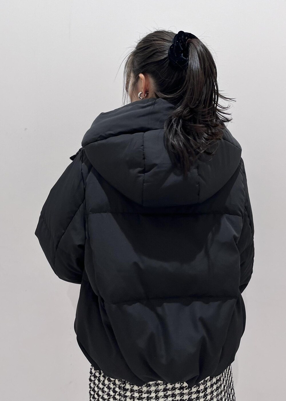 ブラック系のブーツ、ブラック系のスカート、ブラック系のダウンジャケット/コートを着用したレディースの冬コーディネートの6枚目の写真