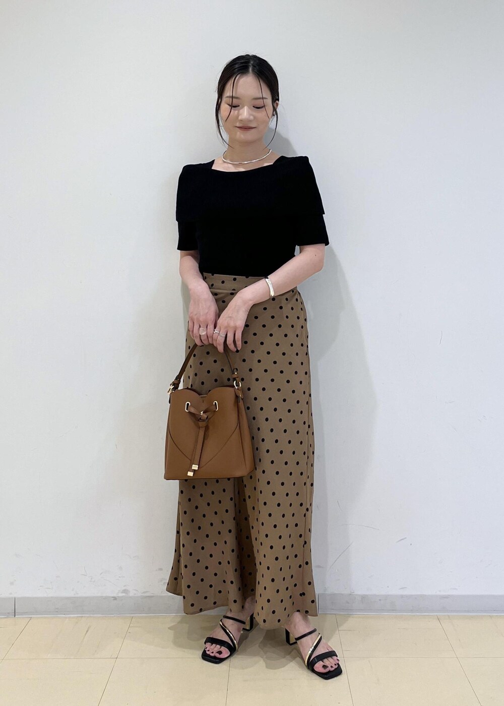 ブラック系のサンダル、ブラウン系のショルダーバッグ、ブラウン系のスカートを着用したレディースの夏コーディネートの4枚目の写真