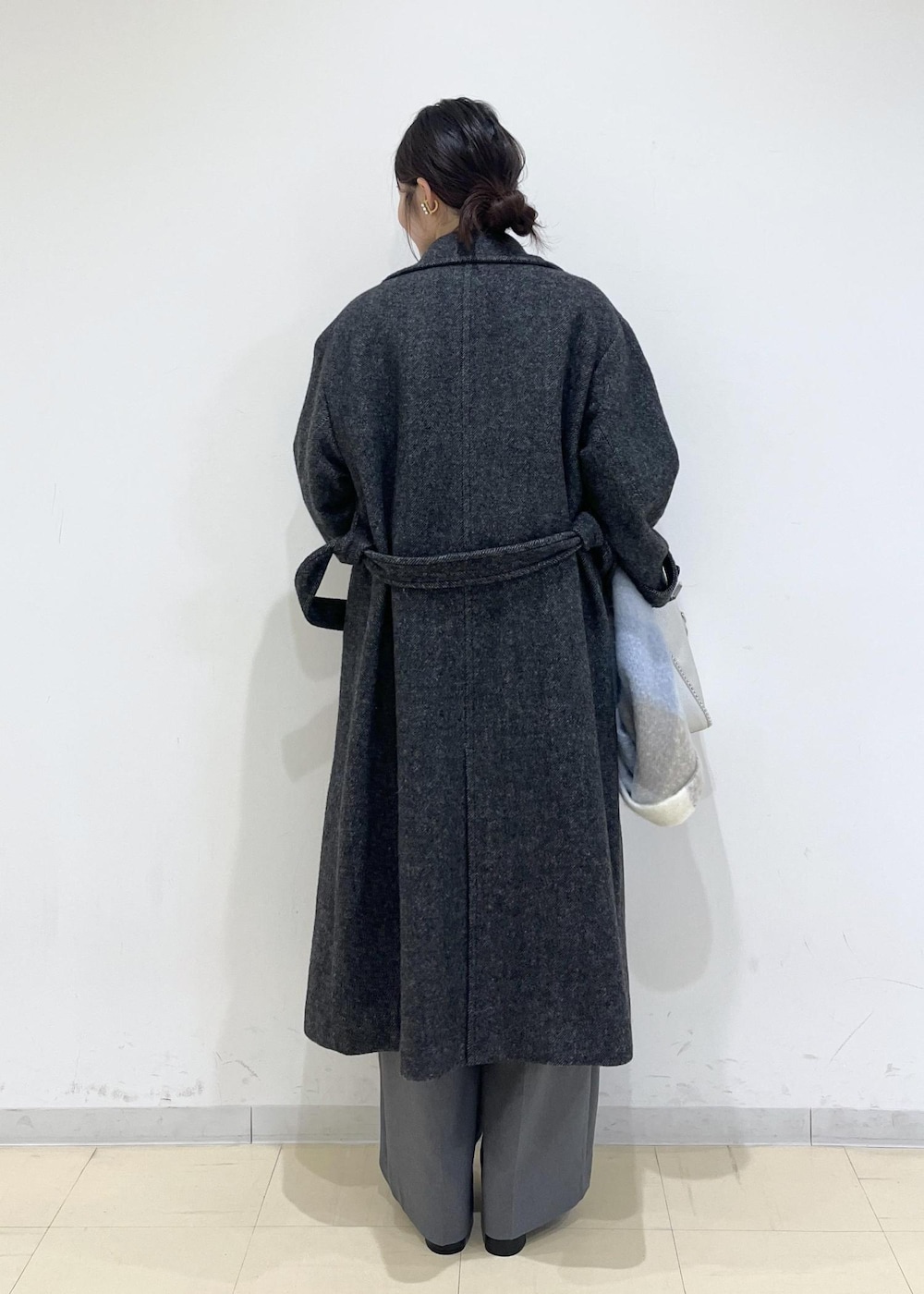 グレー系のスラックス、ホワイト系のベスト、ブルー系のニット/セーターを着用したレディースの秋コーディネートの3枚目の写真