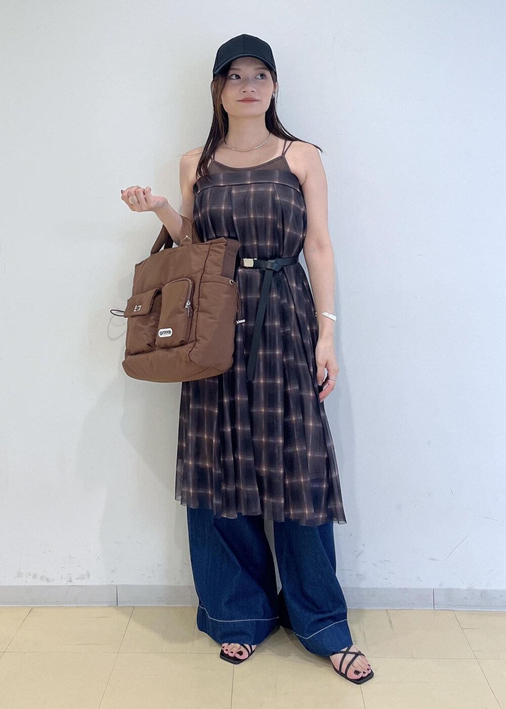 ブルー系のデニムパンツ、ブラウン系のスカート、ブラウン系のキャミソールを着用したレディースの夏コーディネートの9枚目の写真