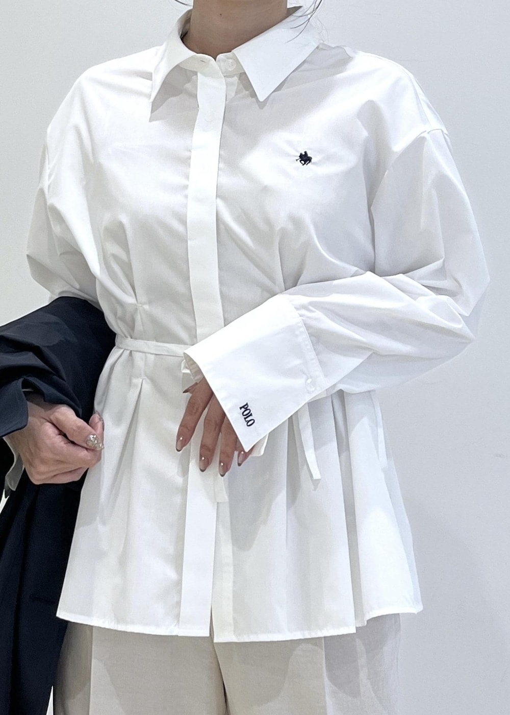 ブラック系のパンプス、ベージュ系のショルダーバッグ、ブルー系のトレンチコートを着用したレディースの春コーディネートの7枚目の写真