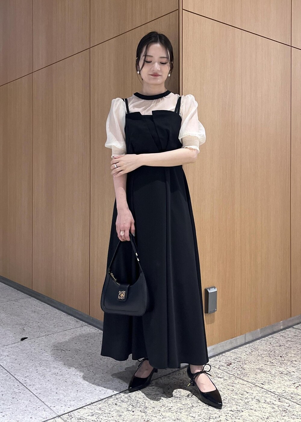 ブラック系のハンドバッグ、ブラック系のパンプス、ブラック系のワンピースを着用したレディースの春コーディネートの3枚目の写真