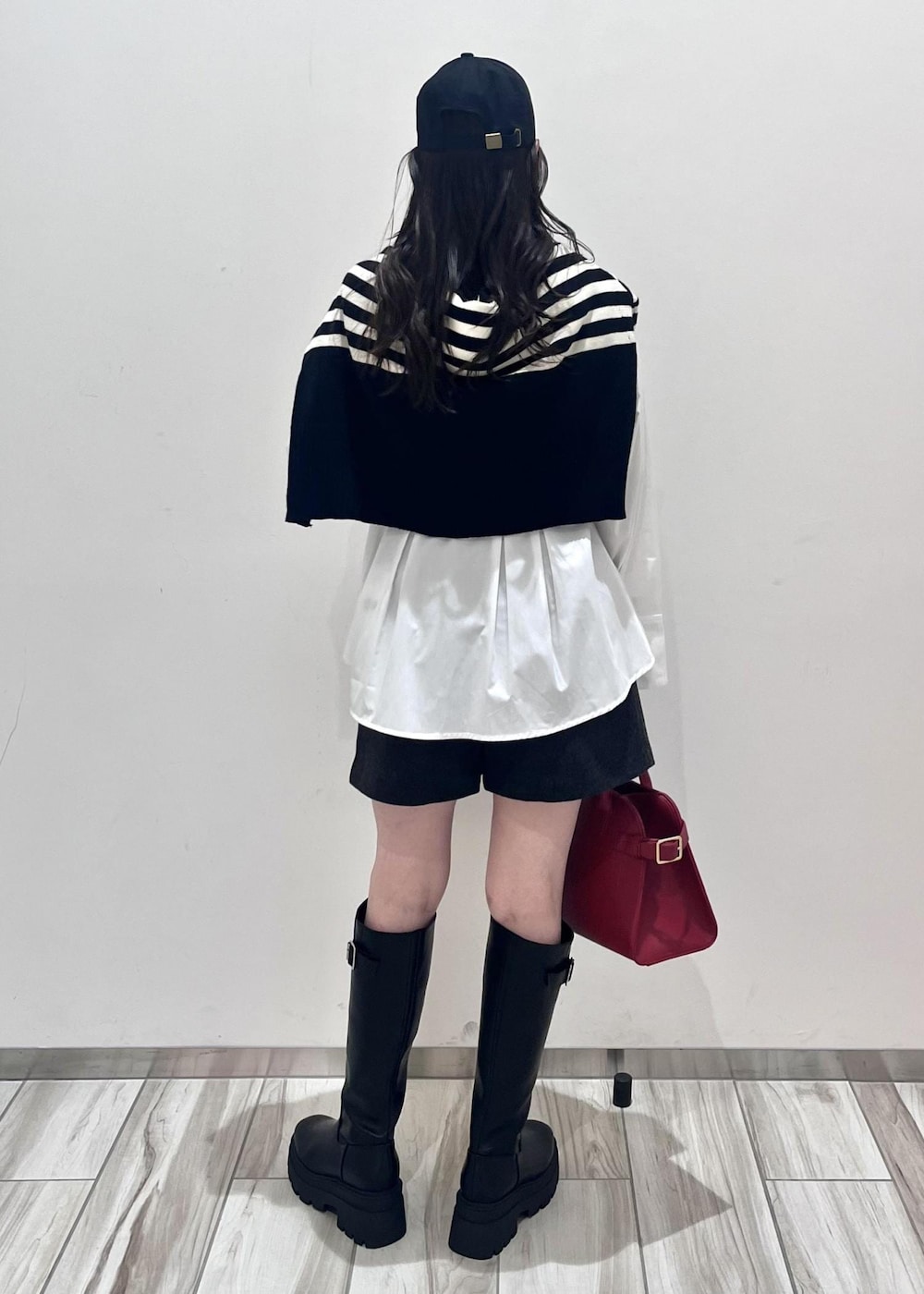 レッド系のトートバッグ、グレー系のその他パンツ、ブラック系のブーツを着用したレディースの秋コーディネートの4枚目の写真