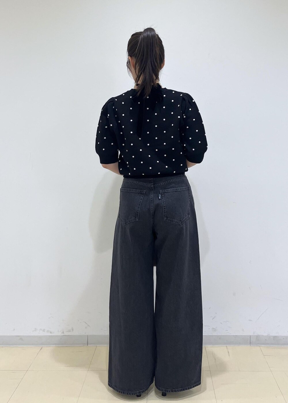 ピンク系のショルダーバッグ、ブラック系のパンプス、ブラック系のニット/セーターを着用したレディースの秋コーディネートの4枚目の写真