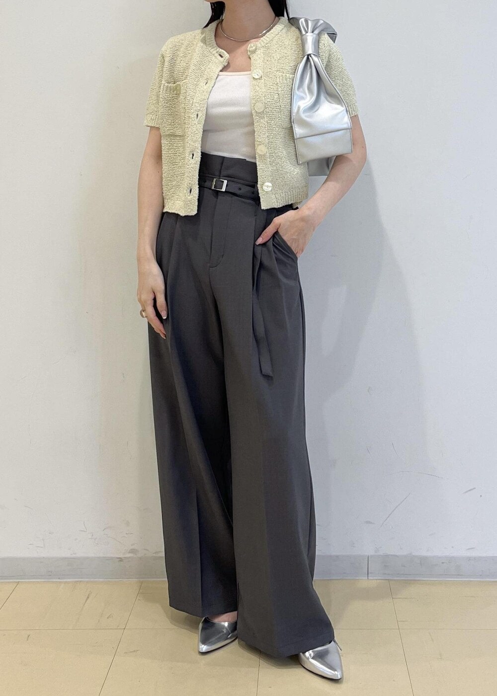 シルバー系のハンドバッグ、シルバー系のパンプス、グリーン系のカーディガン/ボレロを着用したレディースの春コーディネートの10枚目の写真