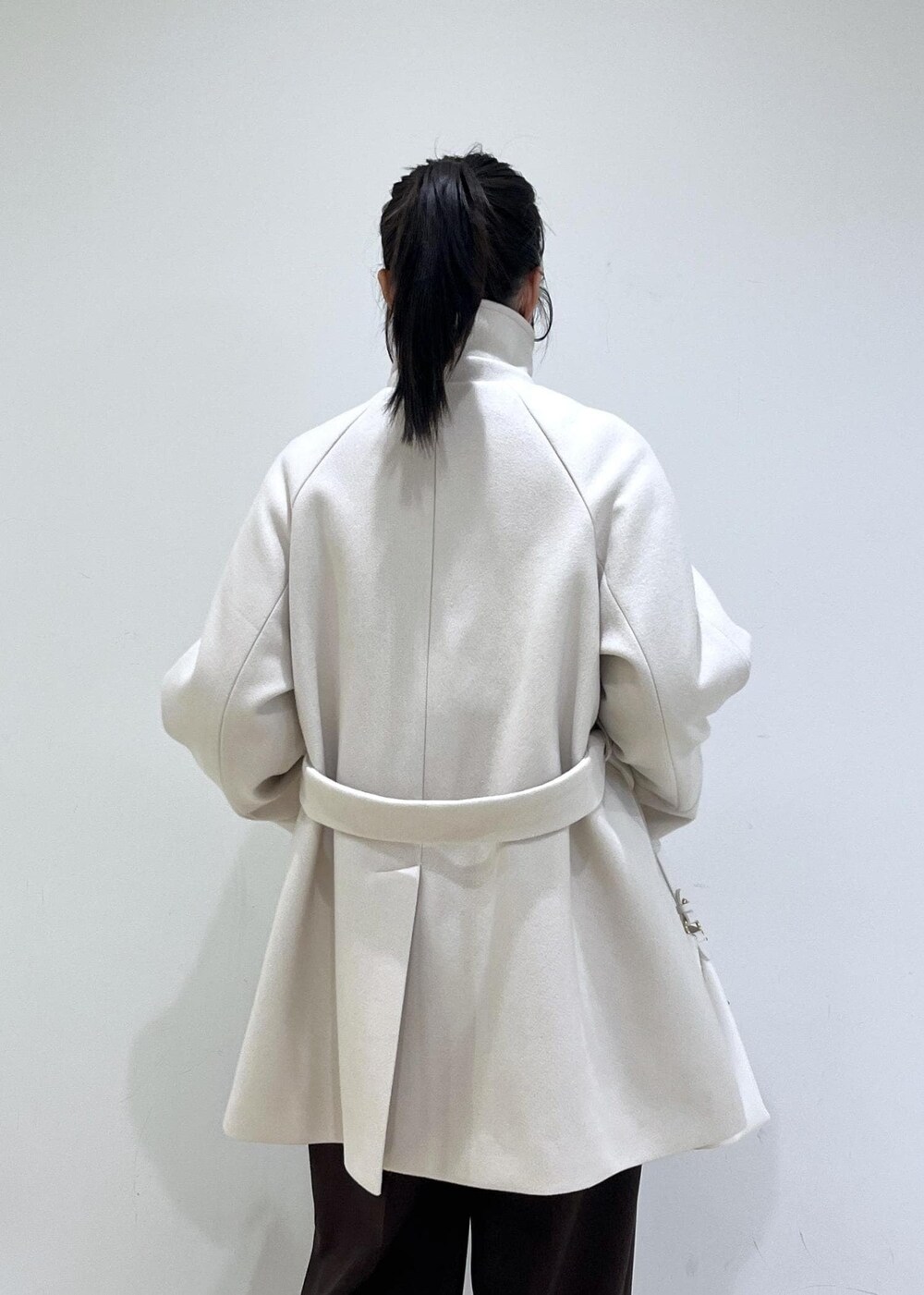 ブラウン系のスラックス、ベージュ系のチェスターコート、ベージュ系のブーツを着用したレディースの冬コーディネートの9枚目の写真