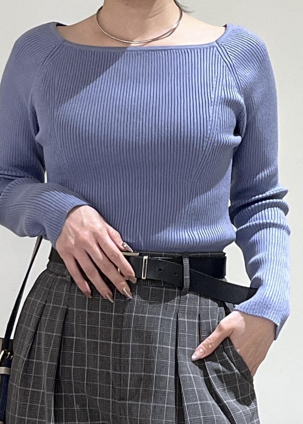 ベージュ系のトートバッグ、ブラック系のテーラードジャケット、ブラック系のチェスターコートを着用したレディースの冬コーディネートの6枚目の写真