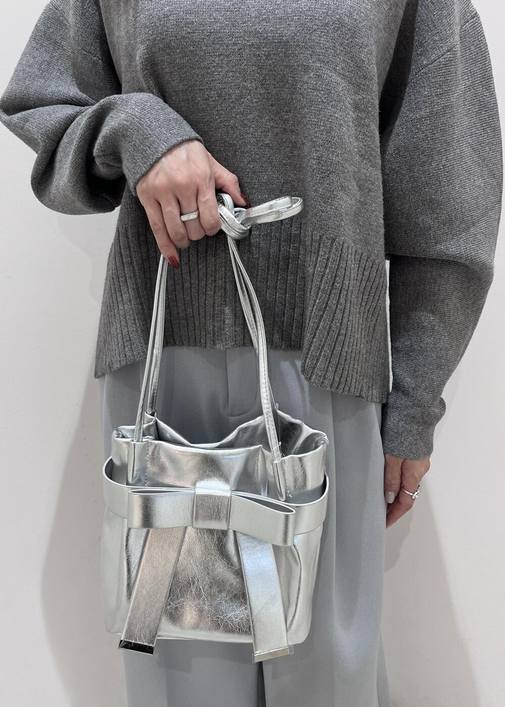 シルバー系のパンプス、シルバー系のショルダーバッグ、ブルー系のスラックスを着用したレディースの秋コーディネートの10枚目の写真