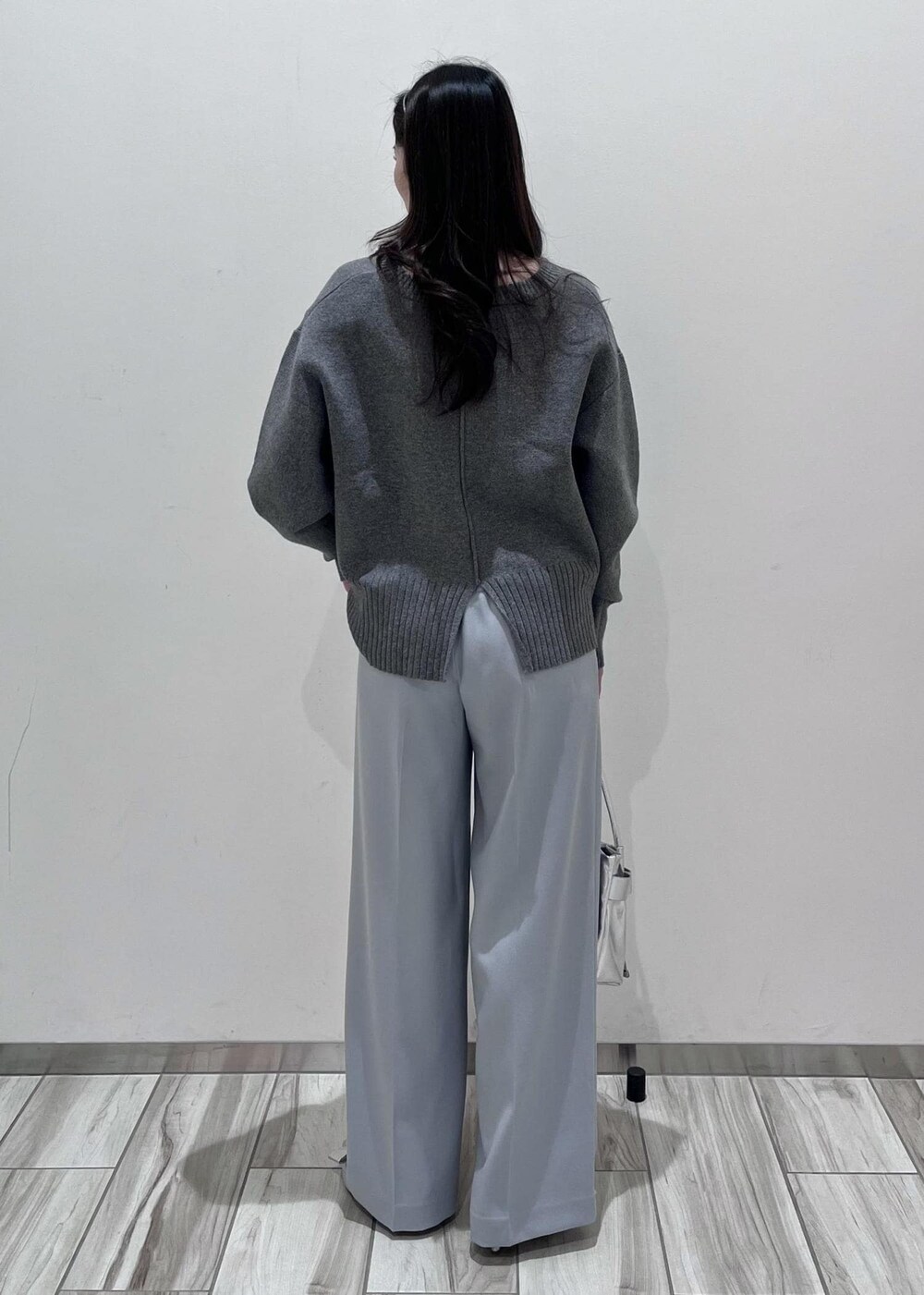 シルバー系のパンプス、シルバー系のショルダーバッグ、ブルー系のスラックスを着用したレディースの秋コーディネートの3枚目の写真