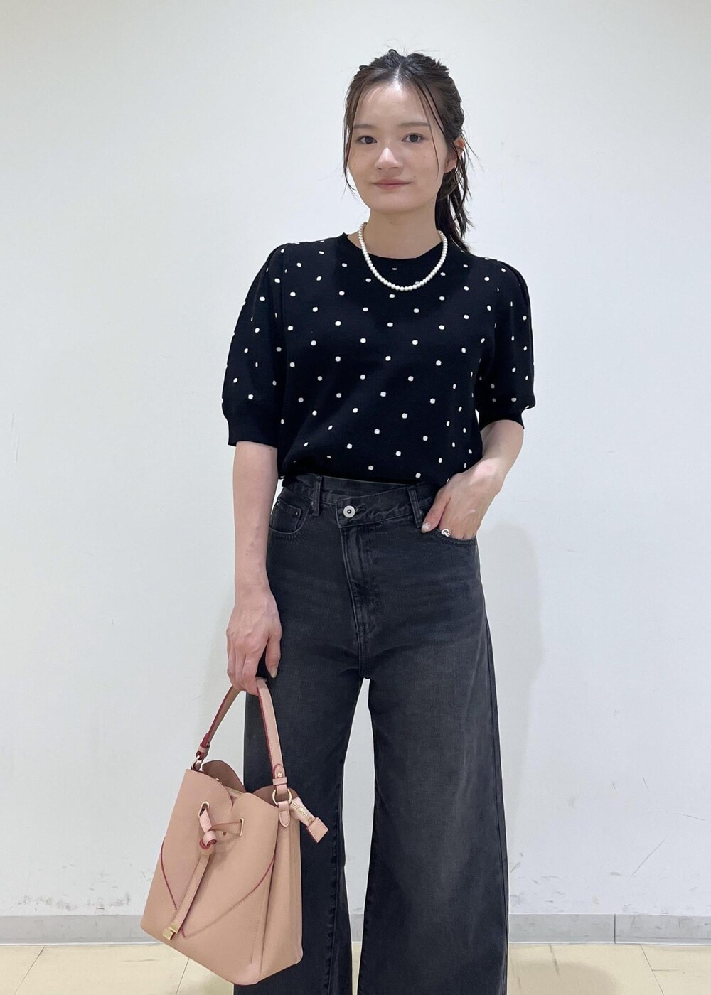 ピンク系のショルダーバッグ、ブラック系のパンプス、ブラック系のニット/セーターを着用したレディースの秋コーディネートの3枚目の写真