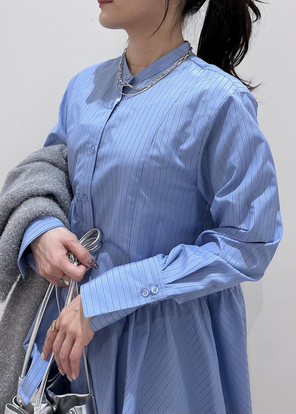 シルバー系のショルダーバッグ、シルバー系のブーツ、グレー系のスラックスを着用したレディースの冬コーディネートの6枚目の写真