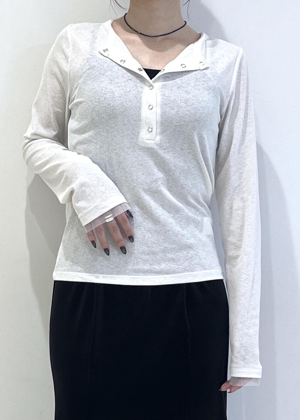 ホワイト系のTシャツ/カットソー、ブラック系のブーツ、ブラック系のスカートを着用したレディースの秋コーディネートの7枚目の写真