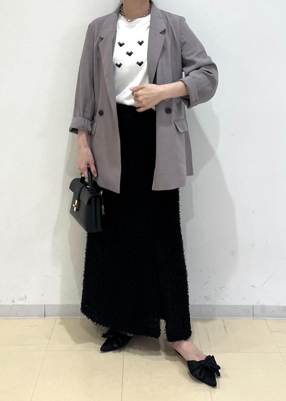 ホワイト系のTシャツ/カットソー、グレー系のテーラードジャケット、ブラック系のサンダルを着用したレディースの夏コーディネートの2枚目の写真