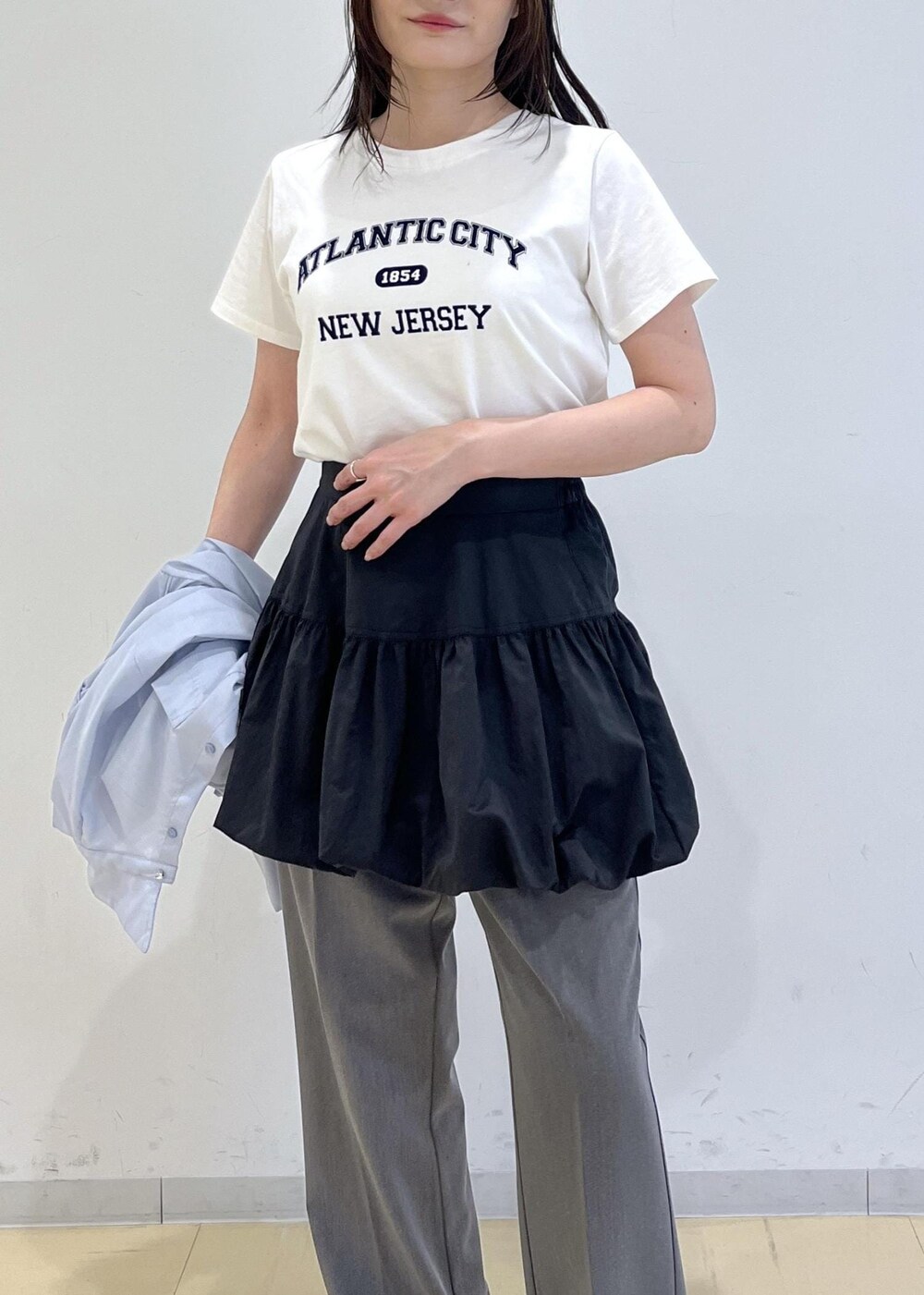 ブラック系のパンプス、ブラック系のスカート、ブルー系のシャツ/ブラウスを着用したレディースの春コーディネートの7枚目の写真