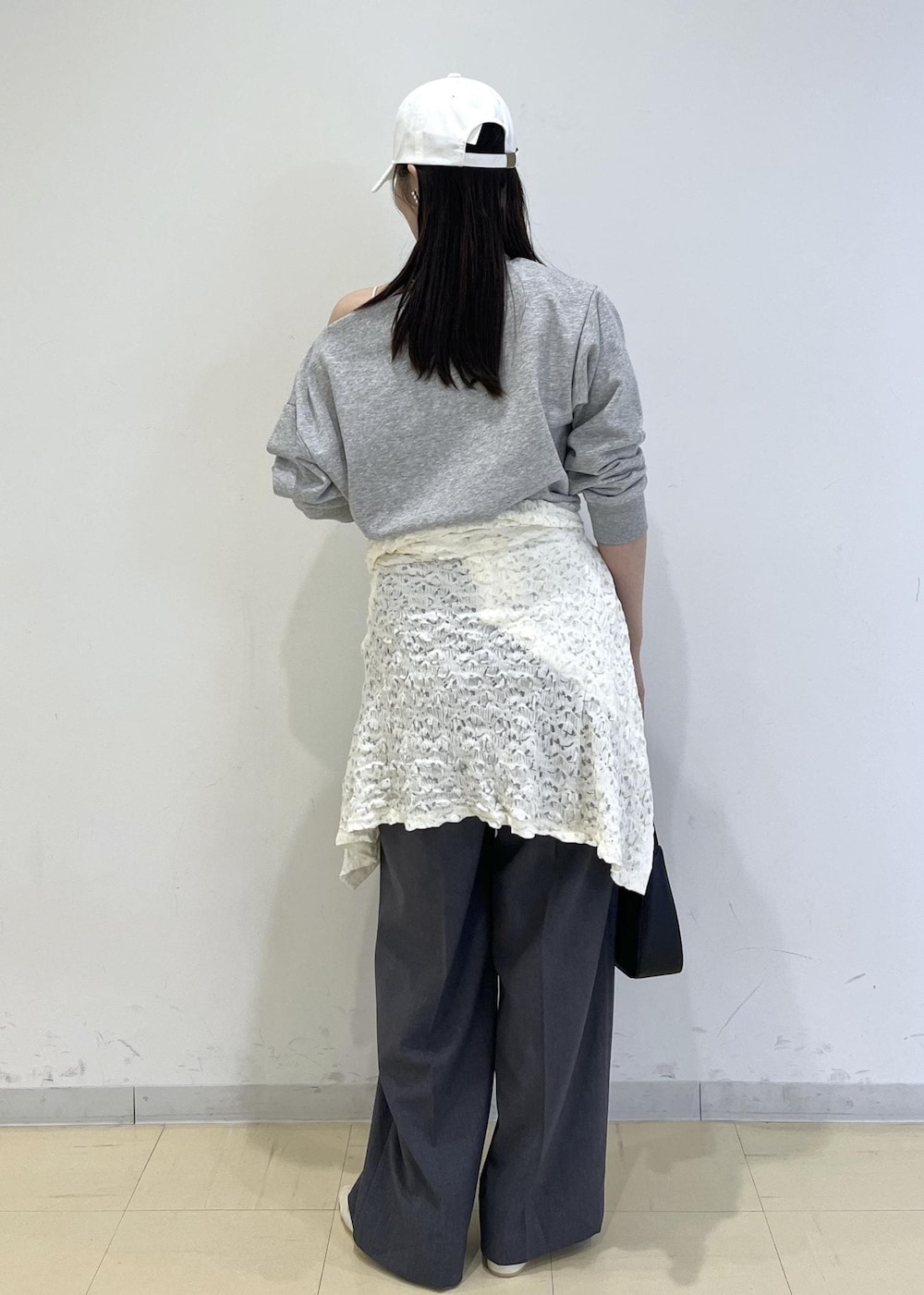 ホワイト系のパンプス、ブラック系のショルダーバッグ、ホワイト系のカーディガン/ボレロを着用したレディースの春コーディネートの2枚目の写真