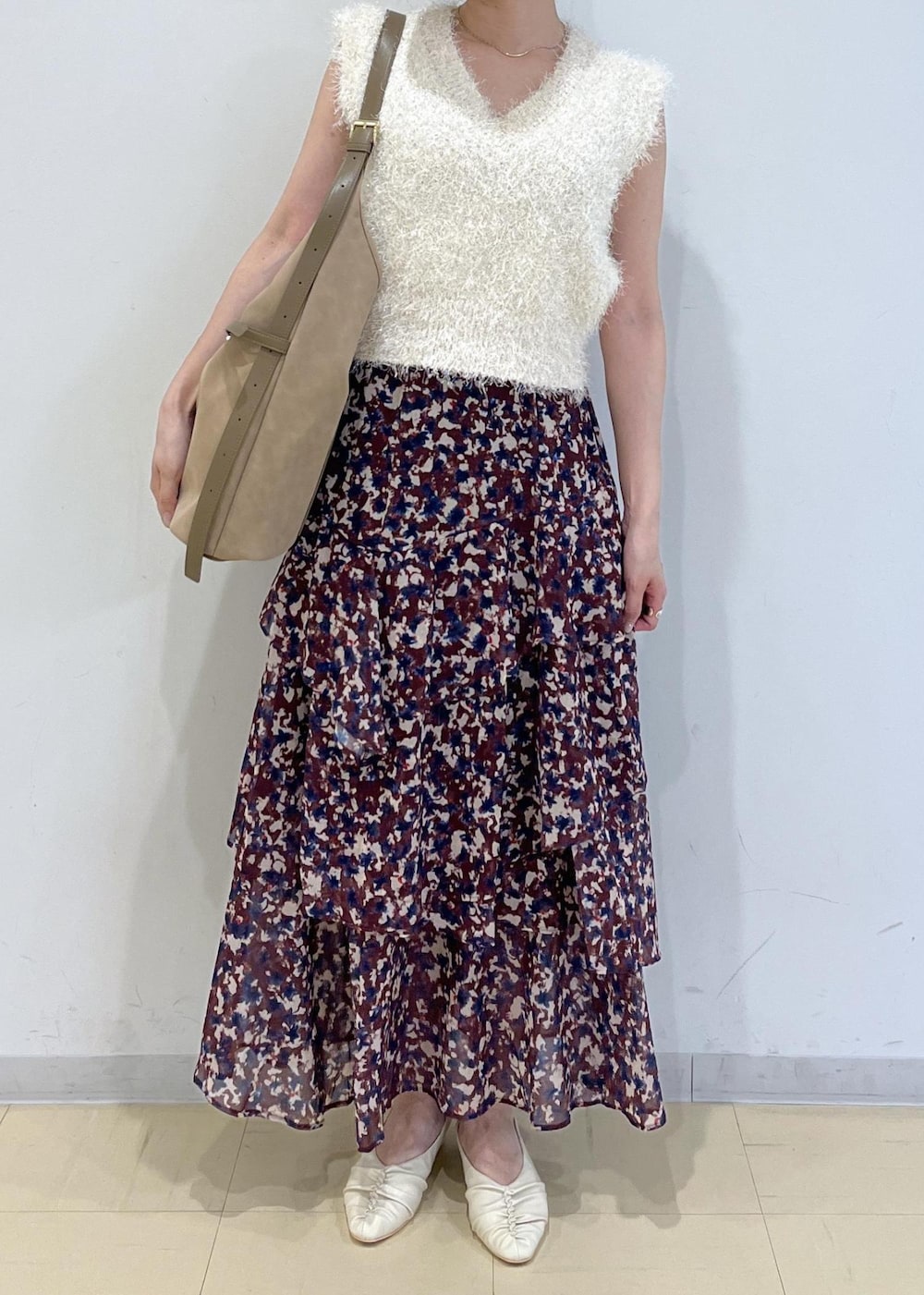 ホワイト系のパンプス、ブラウン系のスカート、ホワイト系のニット/セーターを着用したレディースの秋コーディネートの2枚目の写真