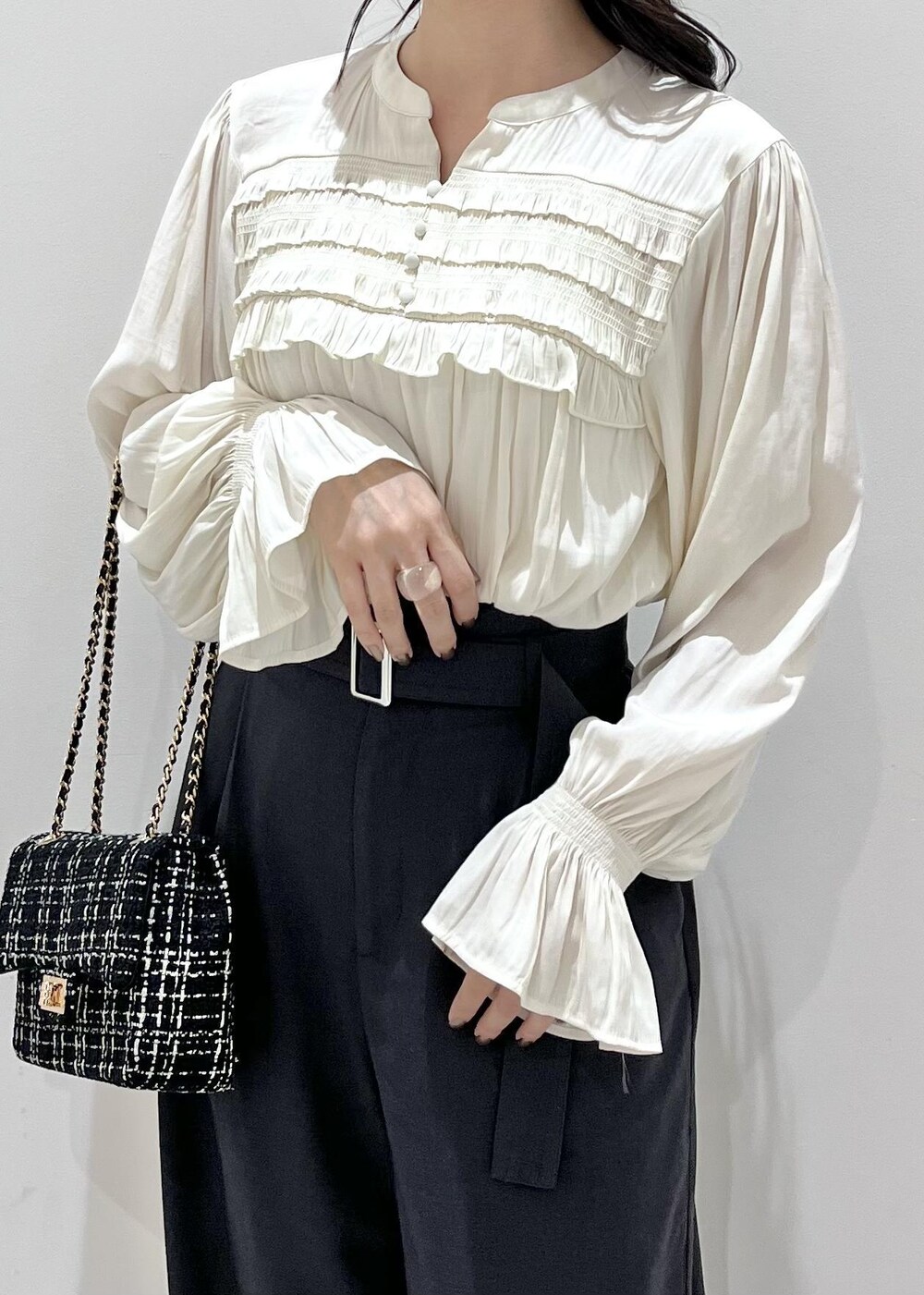 ブラック系のパンプス、ブラック系のショルダーバッグ、ホワイト系のシャツ/ブラウスを着用したレディースの秋コーディネートの3枚目の写真