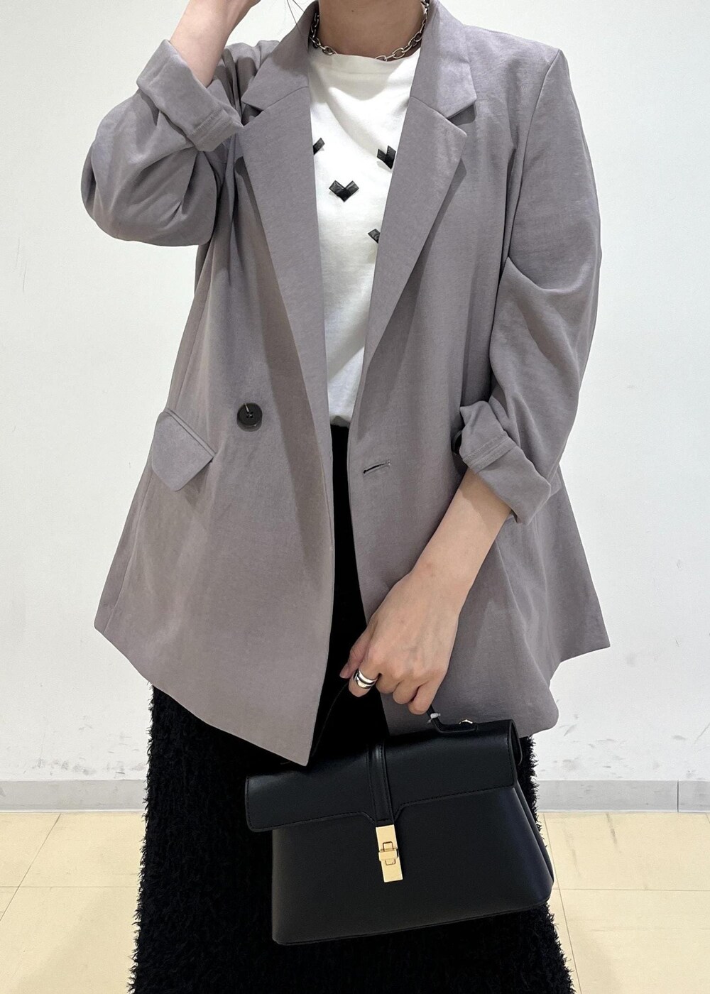 ホワイト系のTシャツ/カットソー、グレー系のテーラードジャケット、ブラック系のサンダルを着用したレディースの夏コーディネートの6枚目の写真