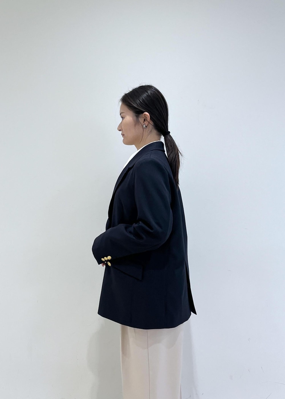 ホワイト系のシャツ/ブラウス、ホワイト系のニット/セーター、ブルー系のテーラードジャケットを着用したレディースの冬コーディネートの4枚目の写真