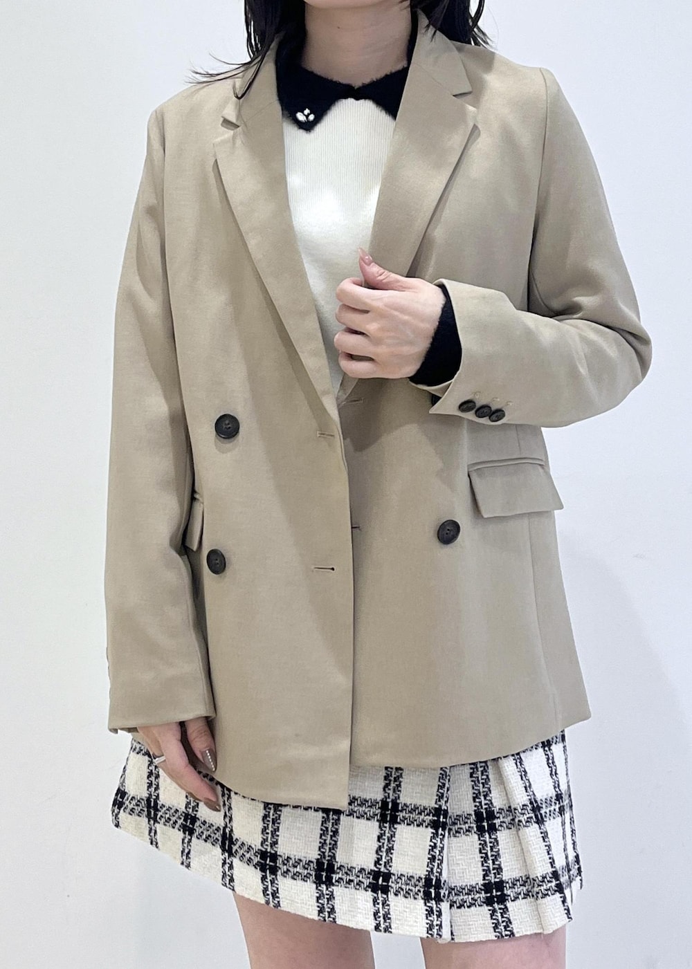 ブラック系のブーツ、ホワイト系のスカート、ホワイト系のニット/セーターを着用したレディースの冬コーディネートの7枚目の写真