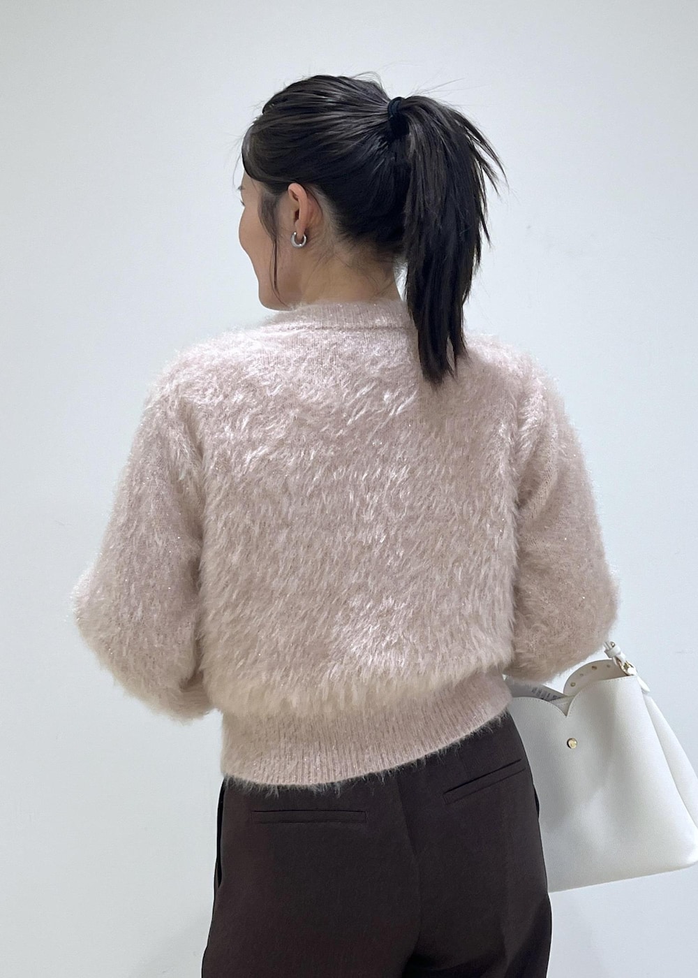 ブラウン系のスラックス、ベージュ系のチェスターコート、ベージュ系のブーツを着用したレディースの冬コーディネートの4枚目の写真