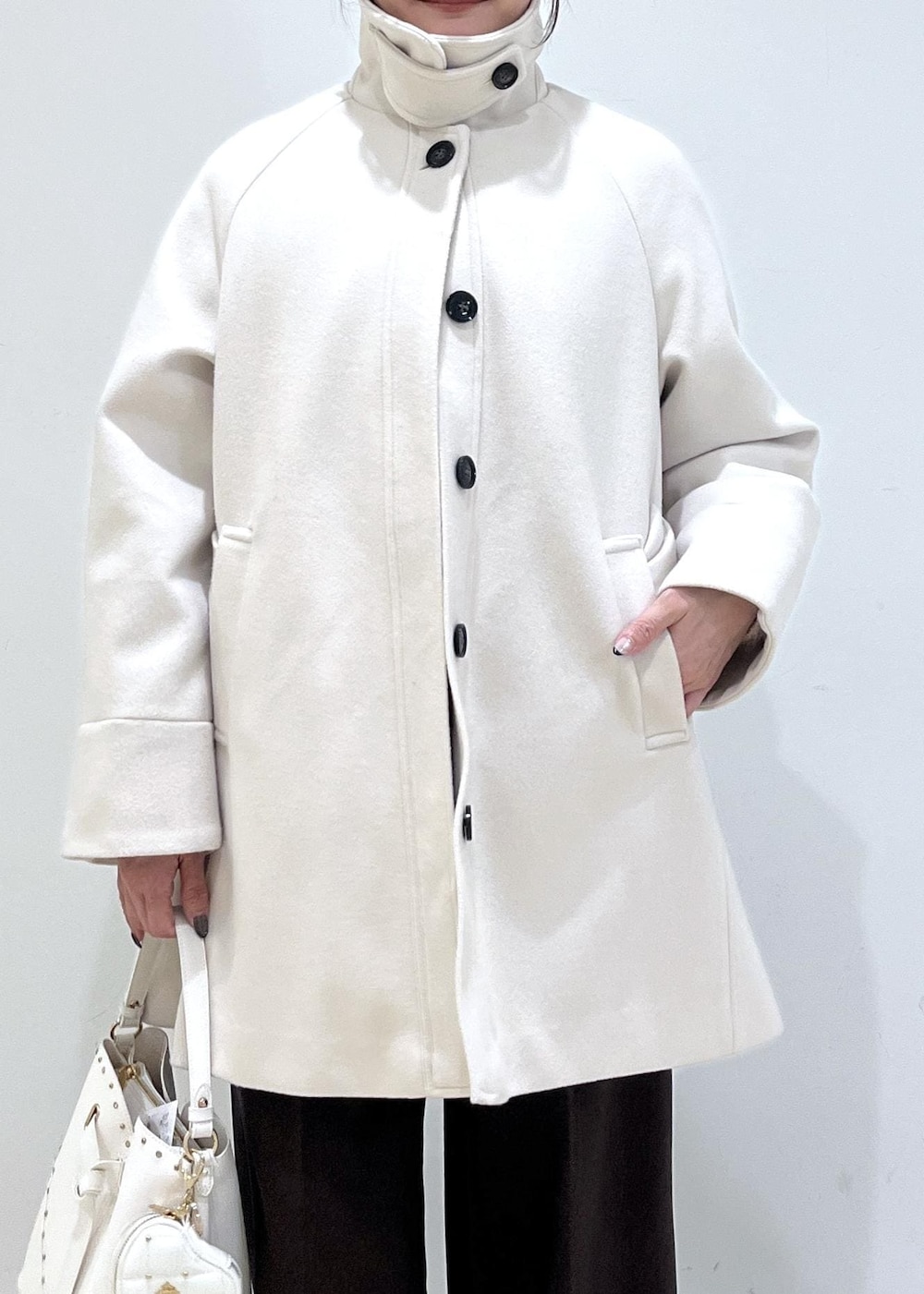 ブラウン系のスラックス、ベージュ系のチェスターコート、ベージュ系のブーツを着用したレディースの冬コーディネートの7枚目の写真