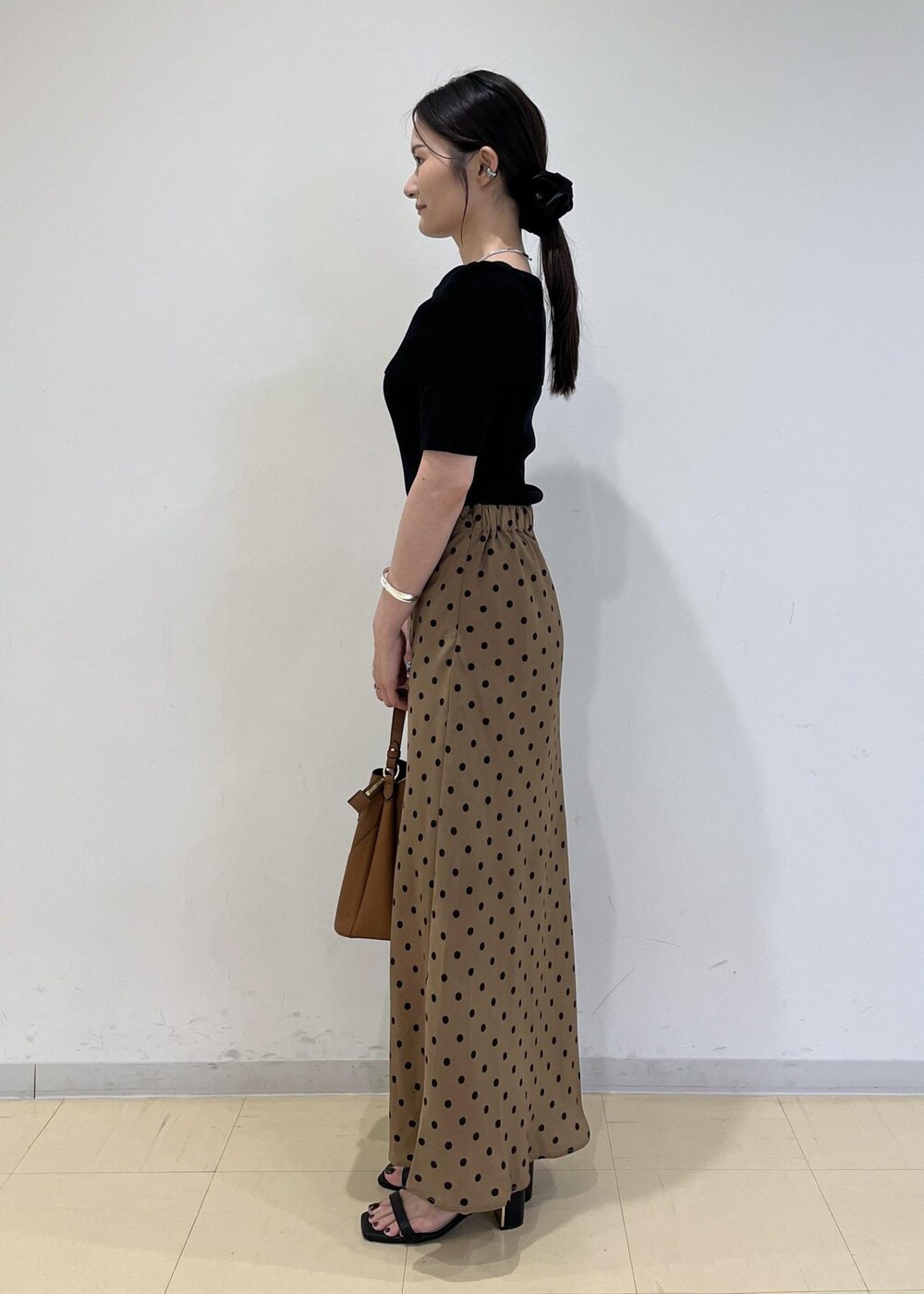 ブラック系のサンダル、ブラウン系のショルダーバッグ、ブラウン系のスカートを着用したレディースの夏コーディネートの2枚目の写真