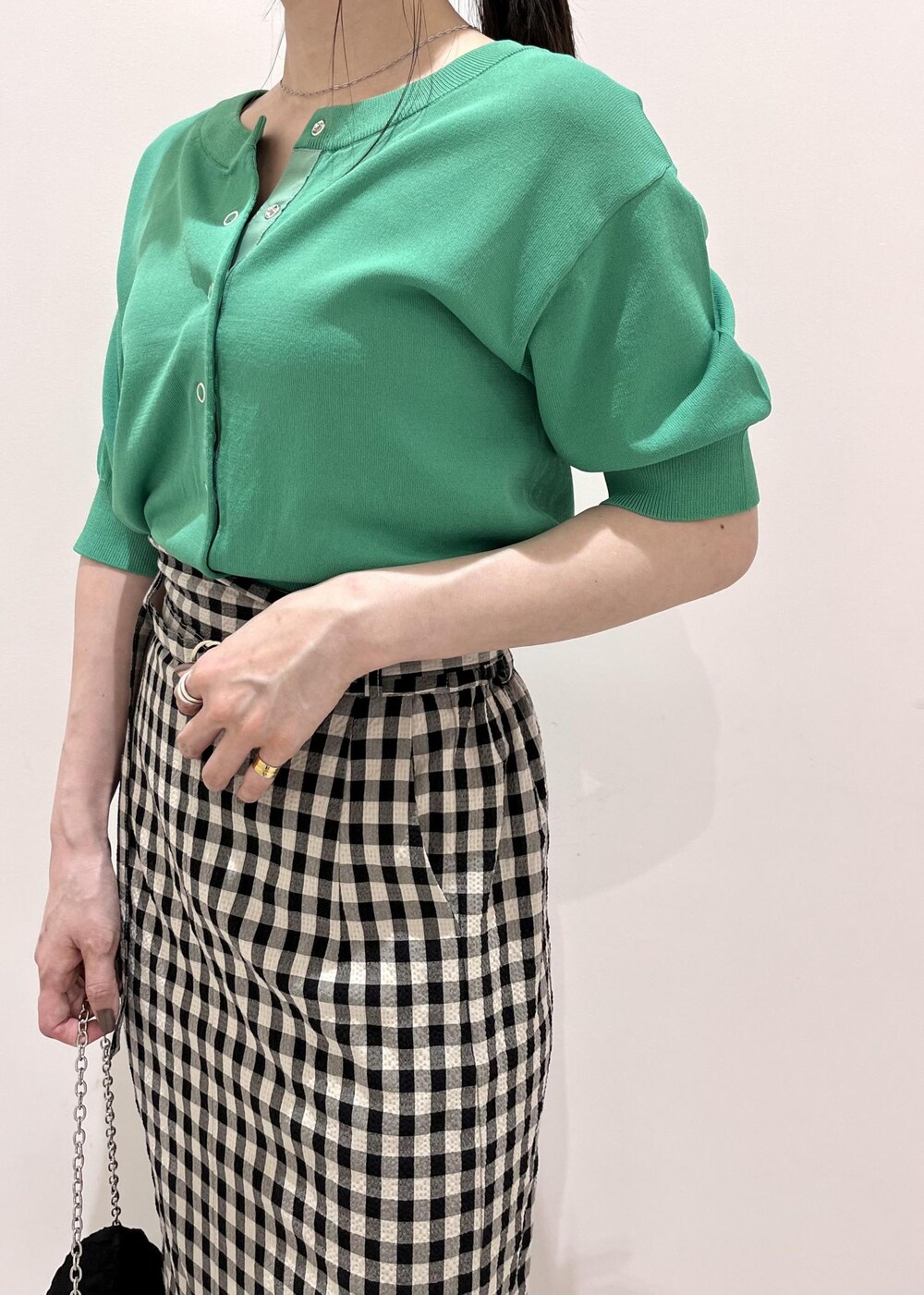 ブラック系のサンダル、ブラック系のスカート、グリーン系のカーディガン/ボレロを着用したレディースの春コーディネートの2枚目の写真