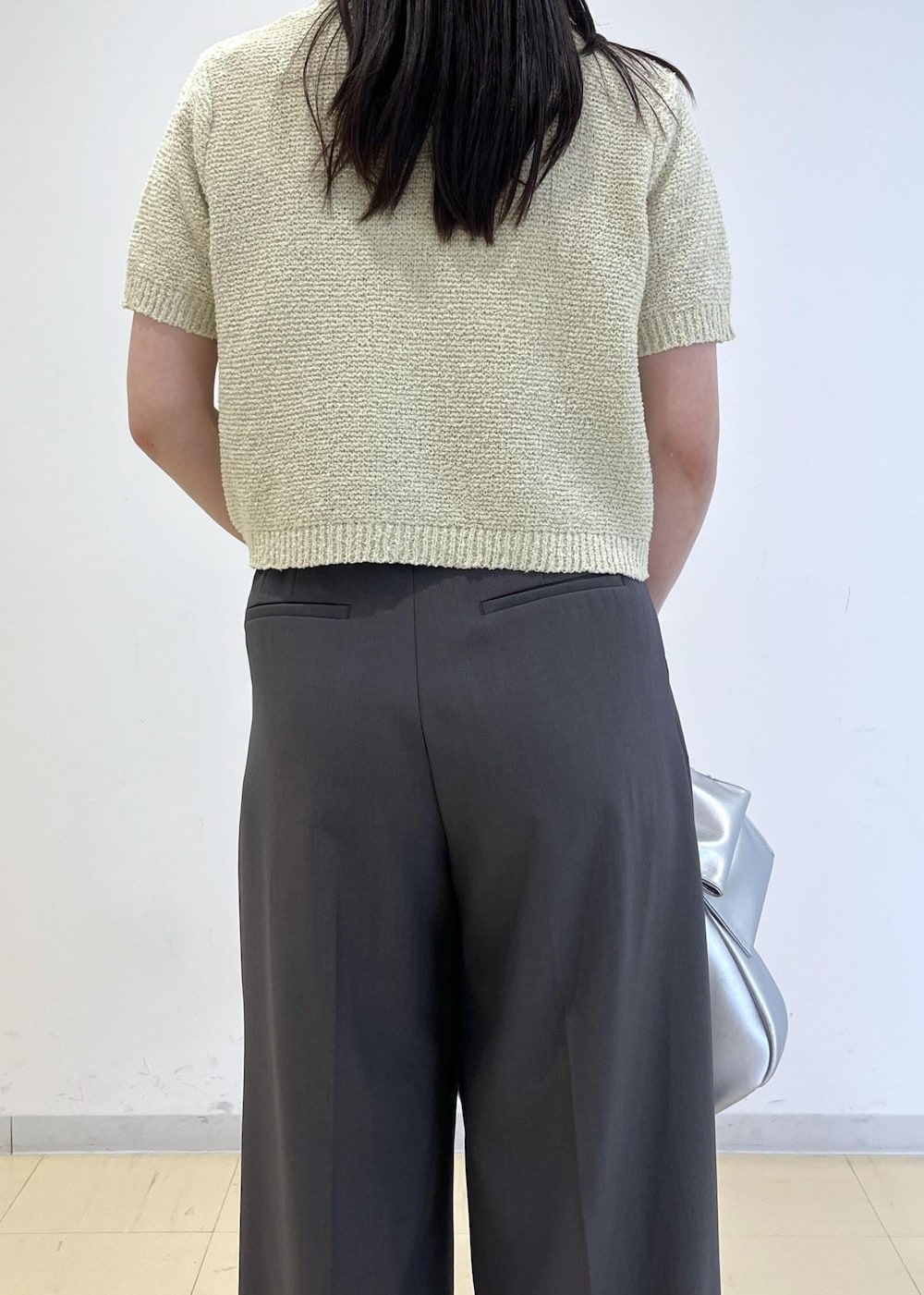 シルバー系のハンドバッグ、シルバー系のパンプス、グリーン系のカーディガン/ボレロを着用したレディースの春コーディネートの9枚目の写真